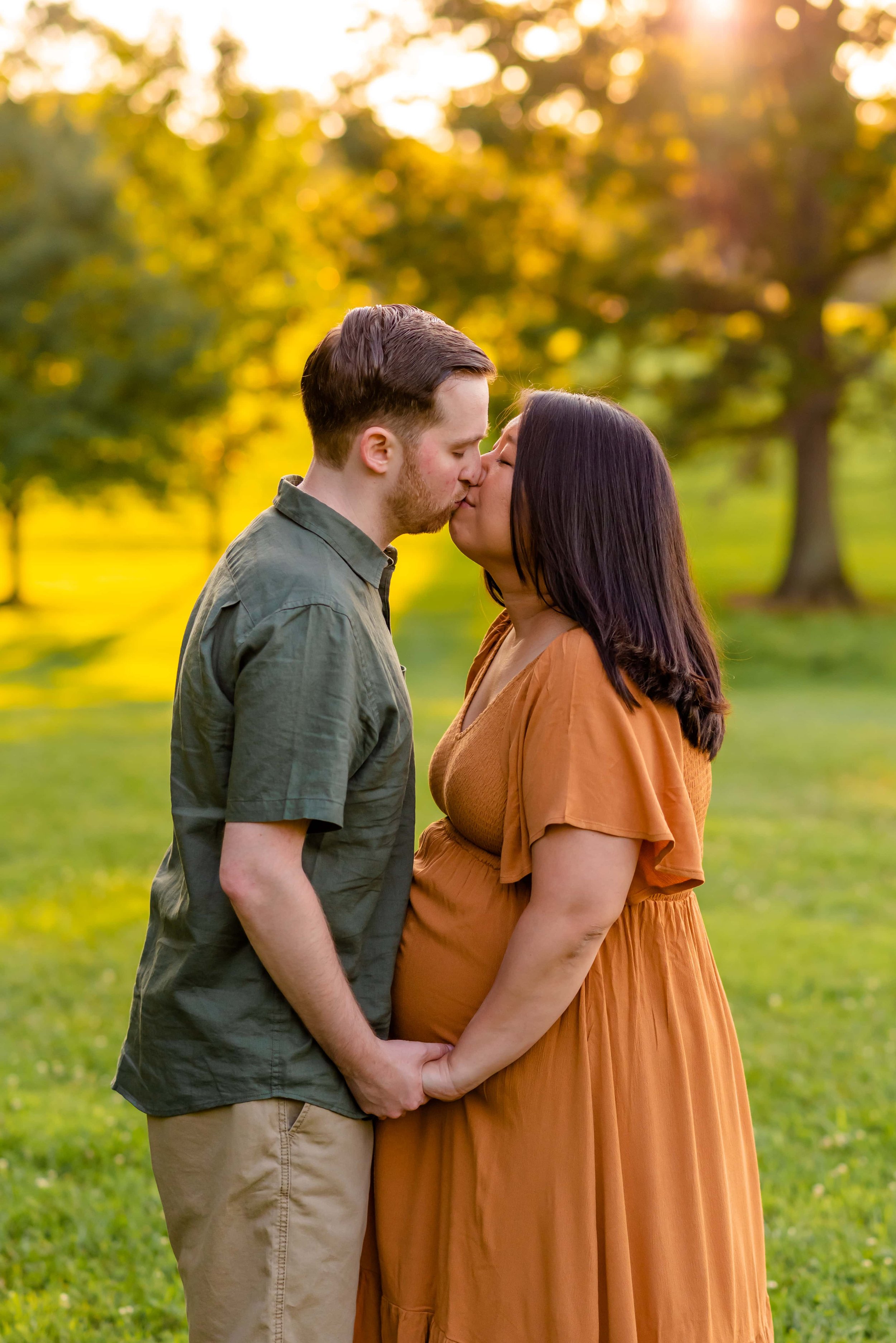 Maryland summer maternity photo of couple at kissing at sunset