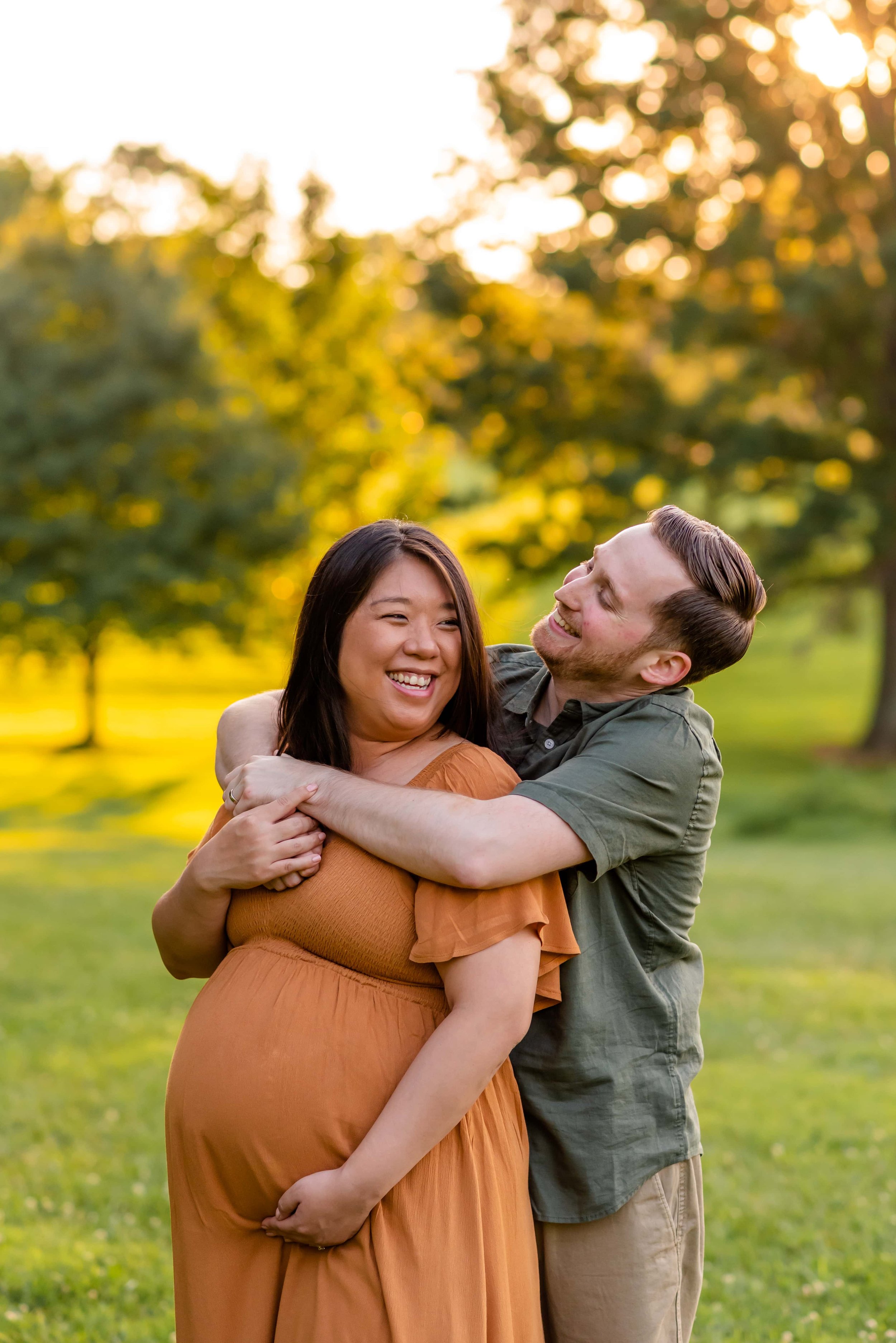 Maryland summer maternity photo of couple hugging and laughing