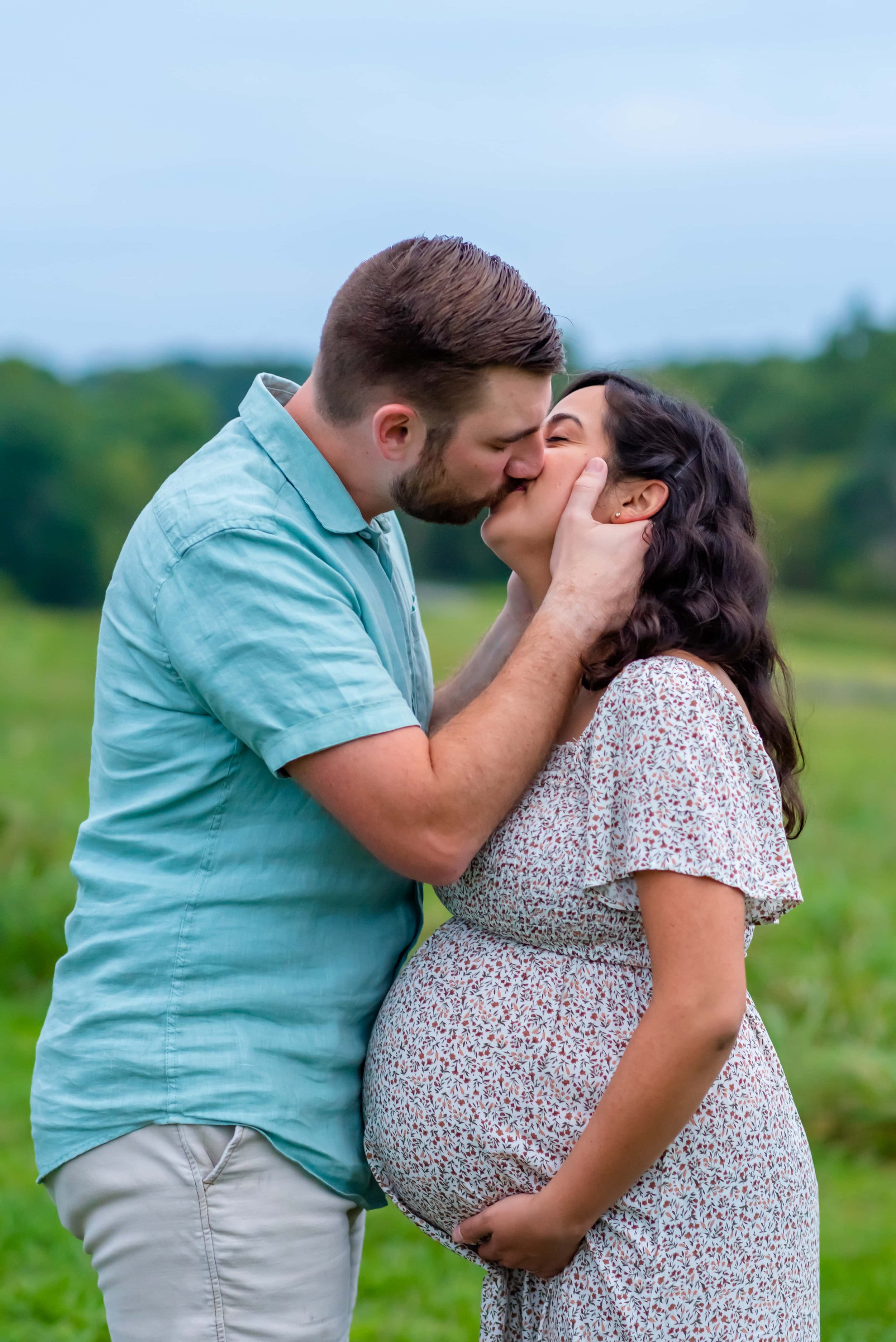 Maryland Maternity photo of couple standing in a field kissing