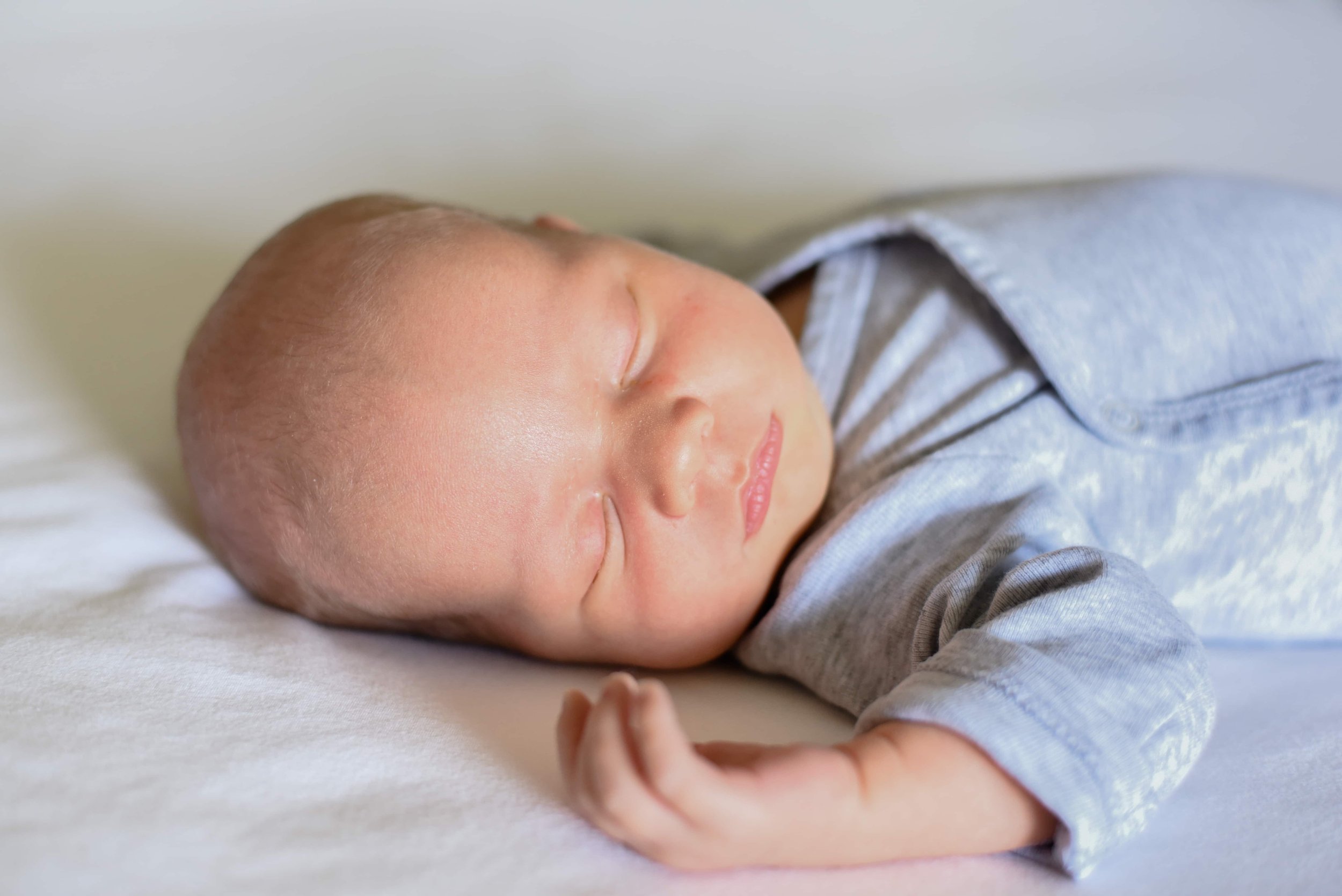 Natural and unposed newborn photograph of sleeping baby