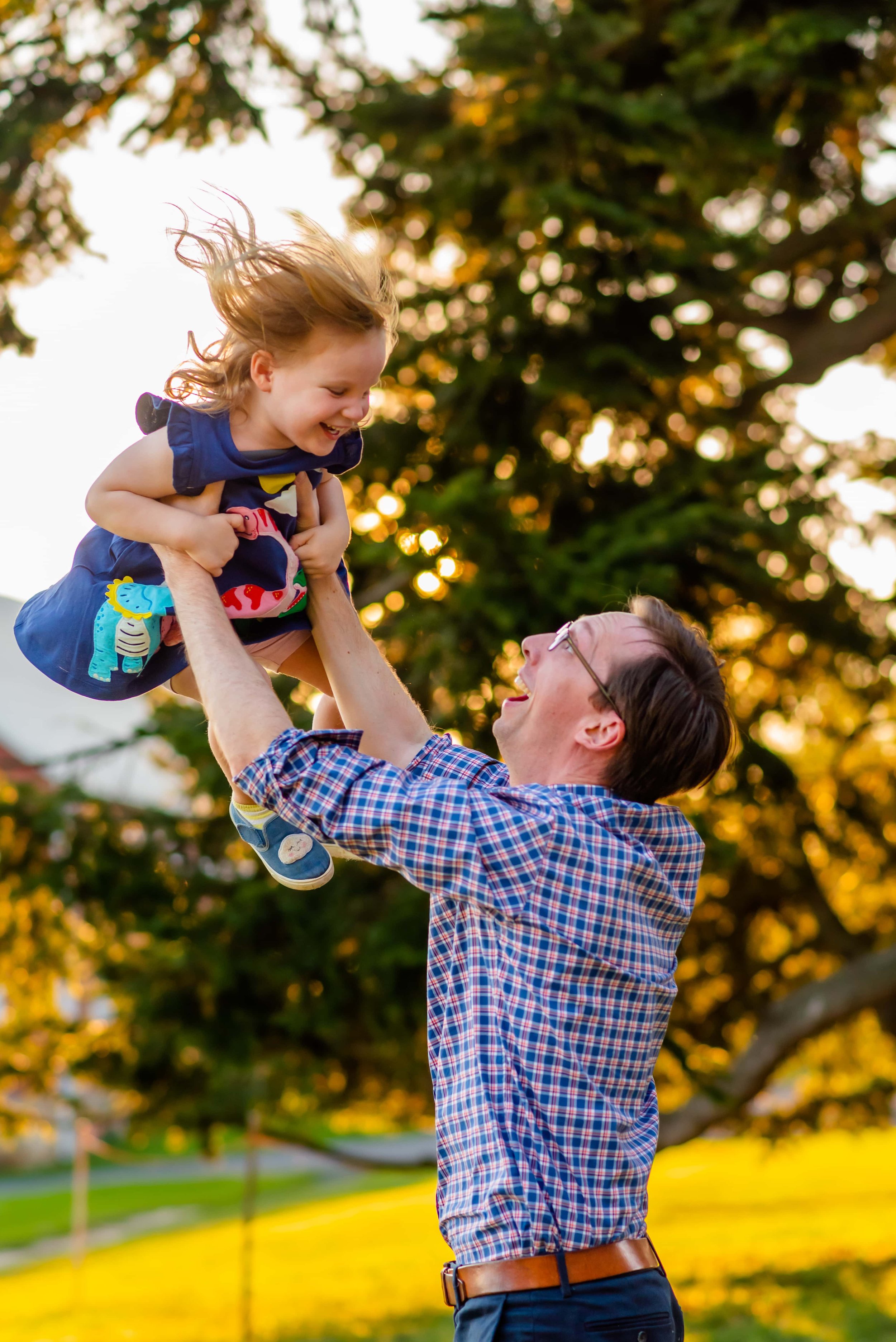 Summer family photo of dad throwing daughter