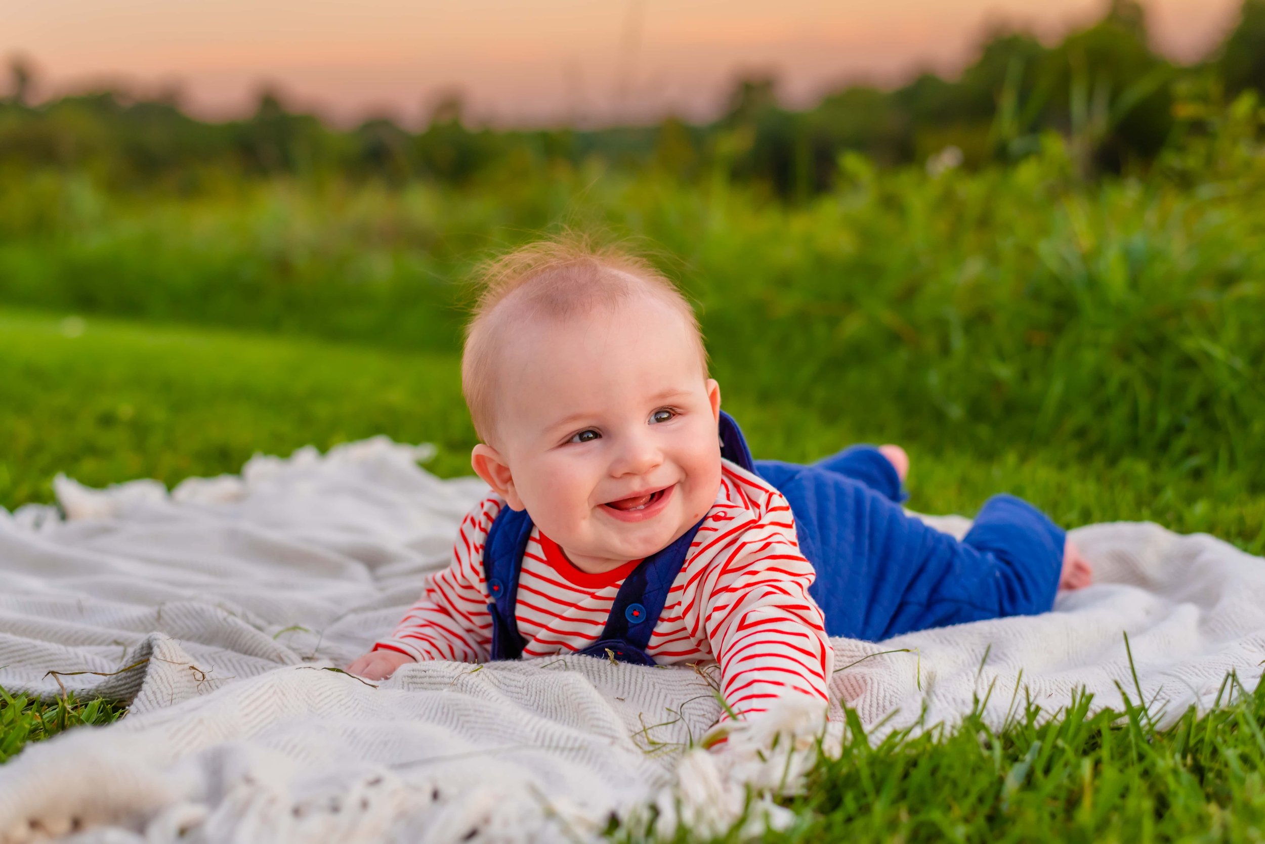 Summer family photo of baby smiling on blanket