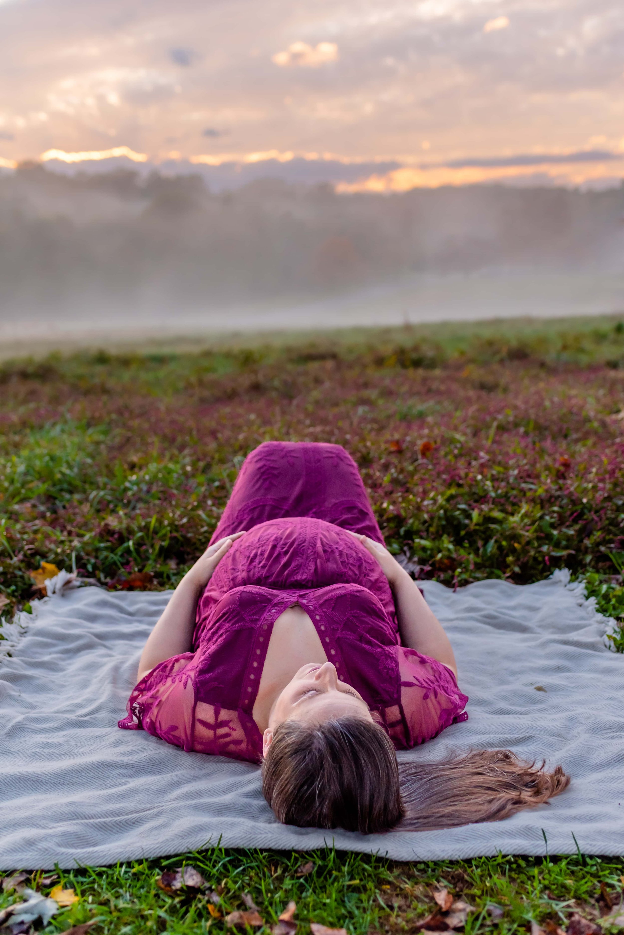 Maryland Maternity Photos - Pregnant woman laying in a field at sunset with fog