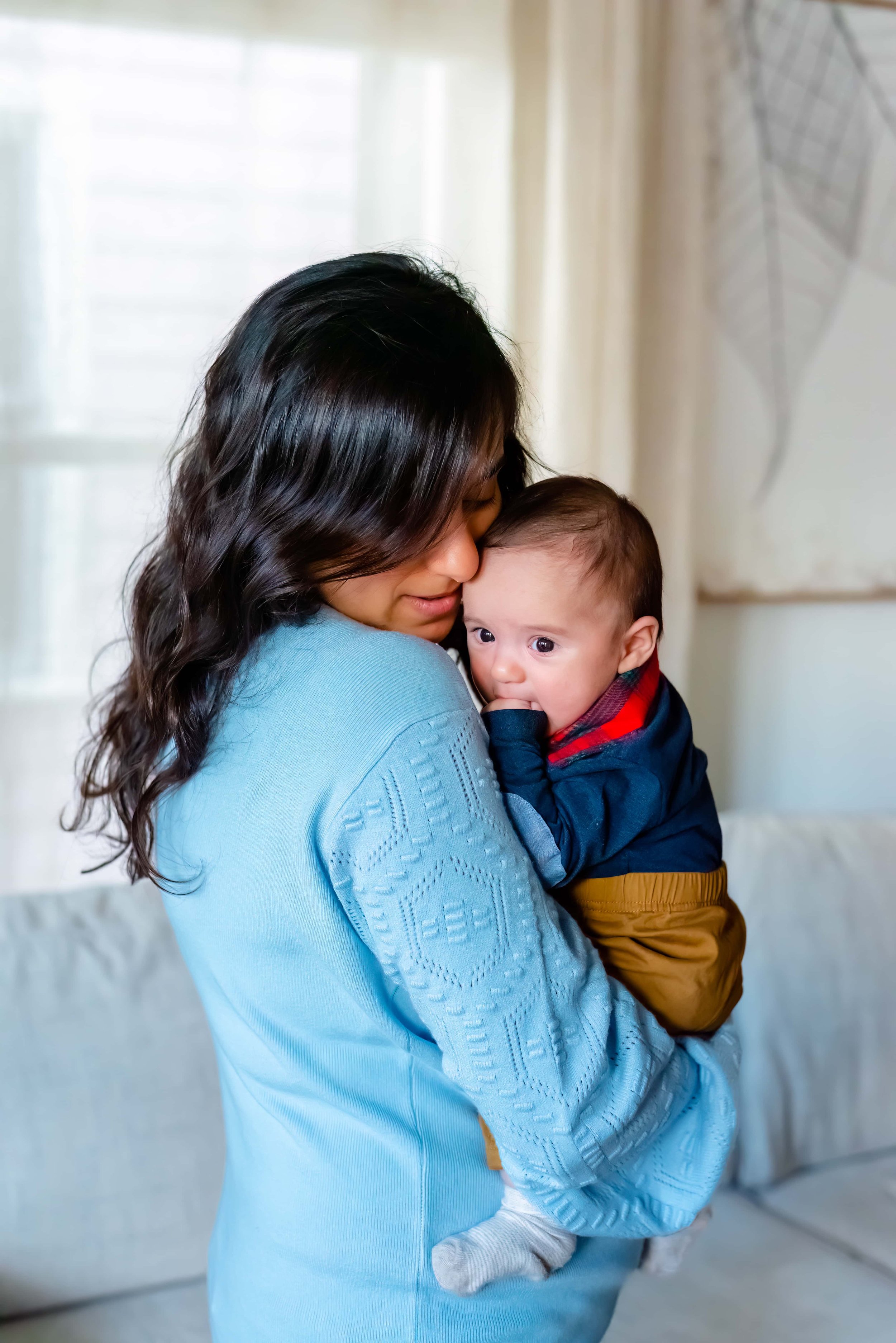 Newborn photograph with mom snuggling and holding baby on her shoulder