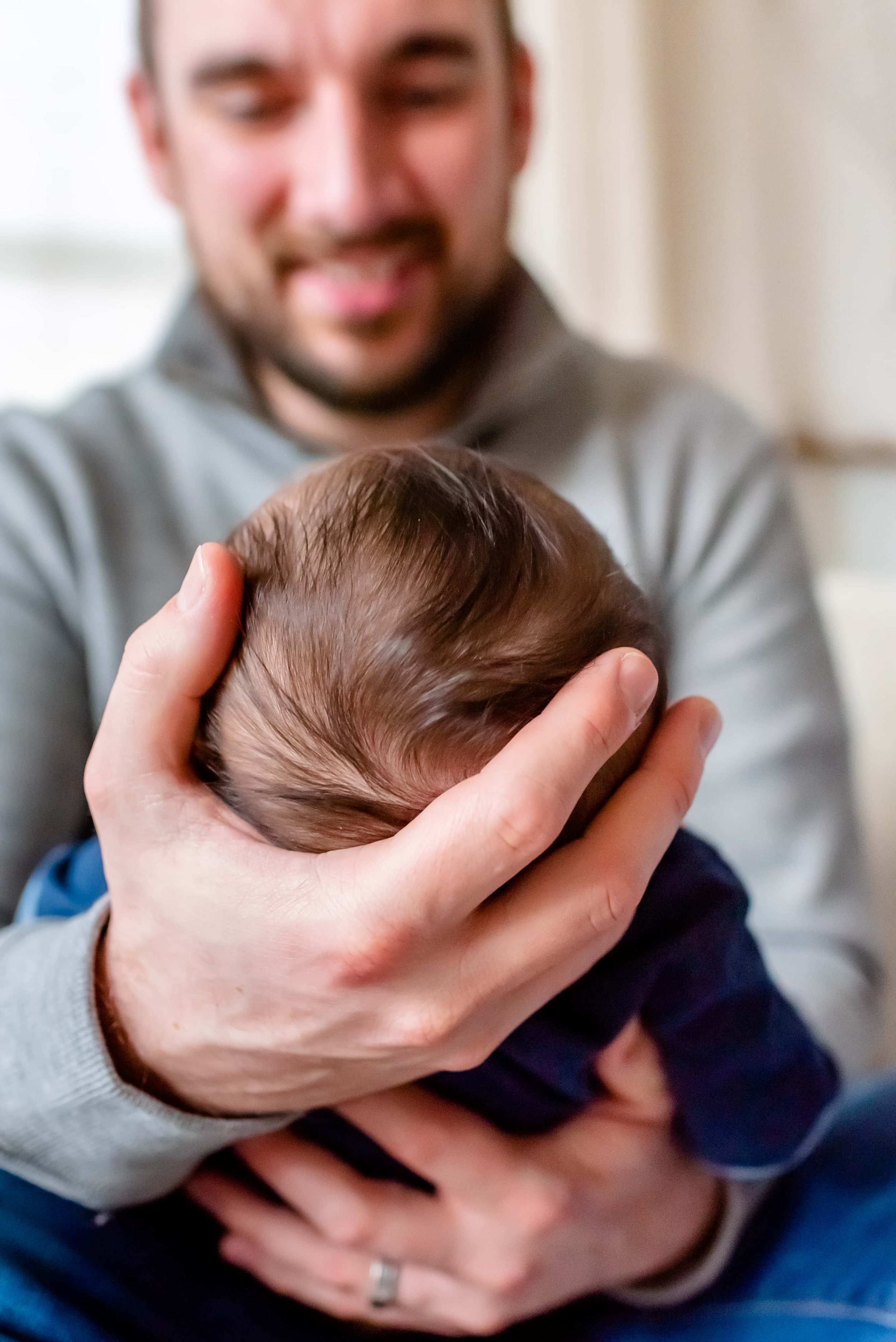 Maryland Newborn Photo - closeup of baby 's head in dad's hand