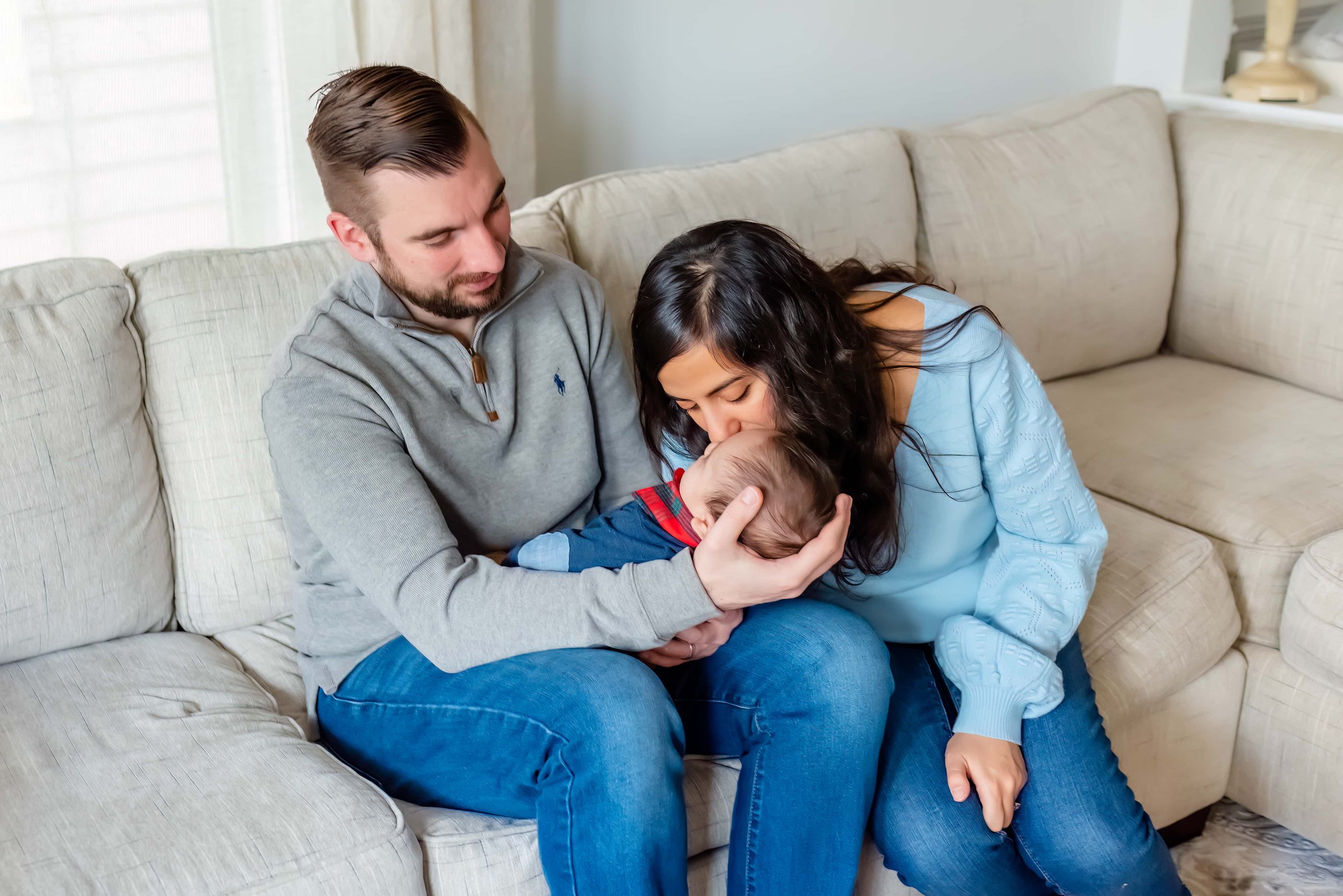 Newborn photo with mom, dad and baby sitting on couch