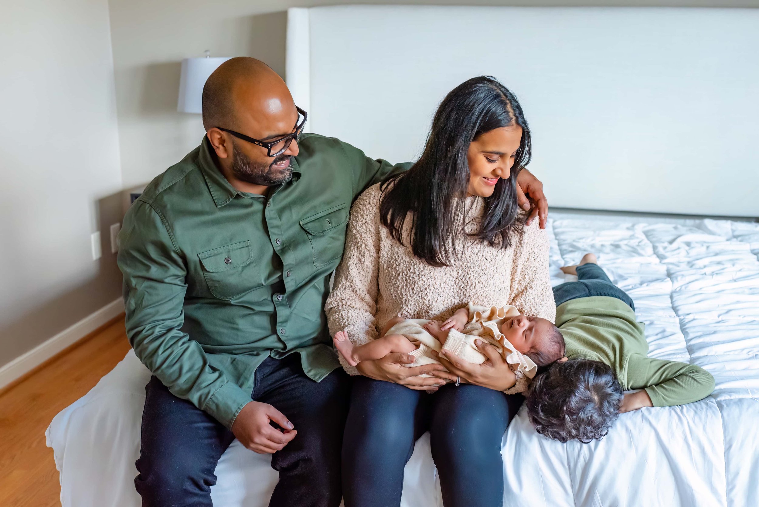 Maryland Newborn Photographer - Mom, dad, toddler and baby  sitting and laying on the bed