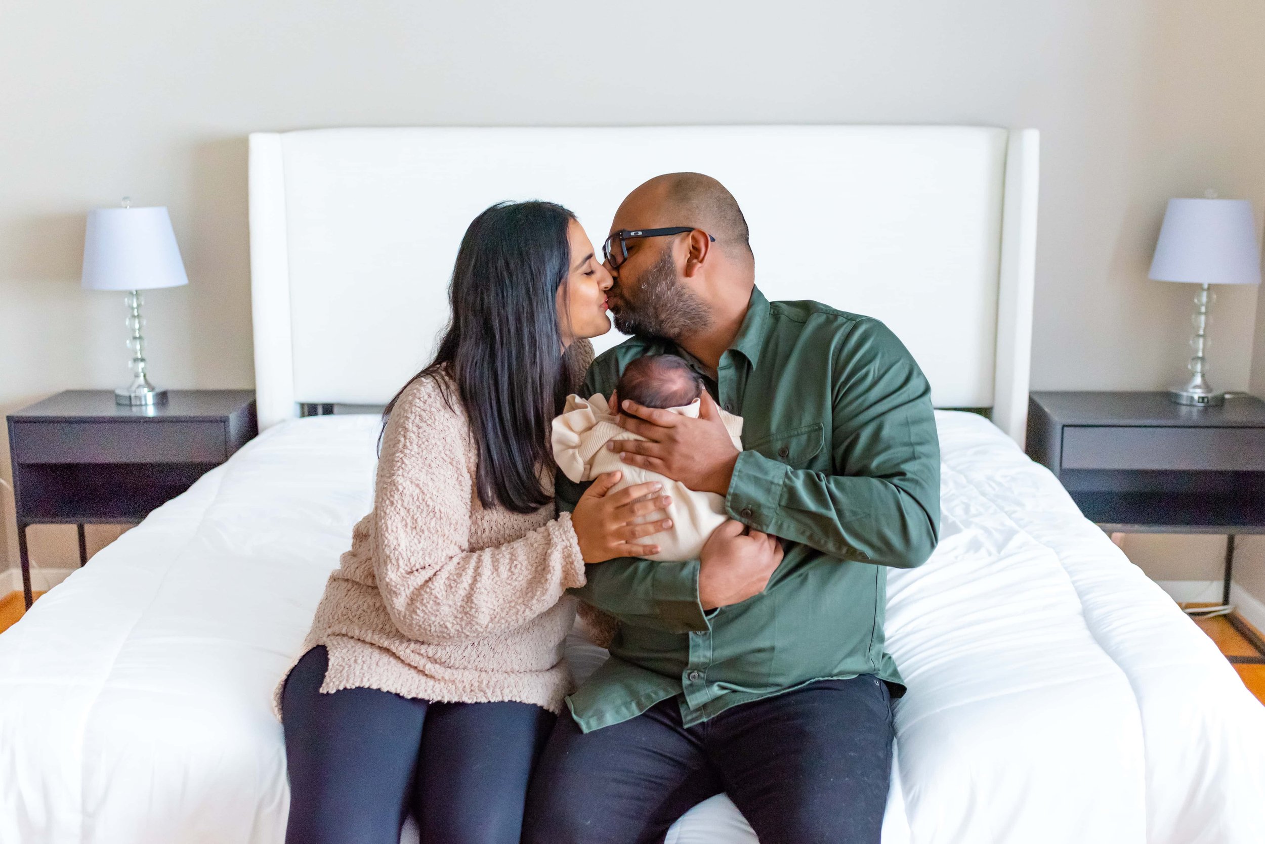 Newborn photography session - mom and dad kissing