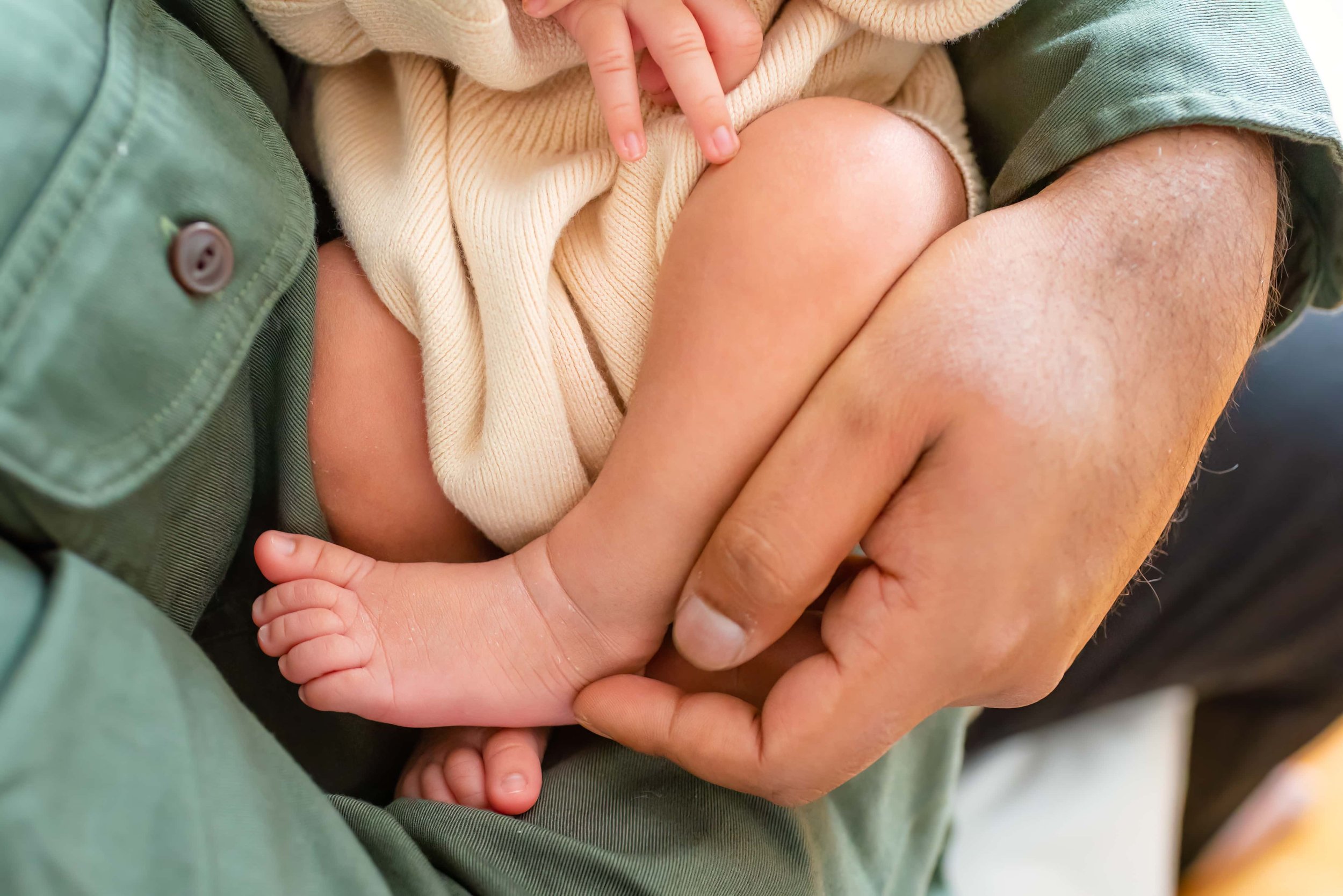 Maryland Newborn Photography - closeup of baby's legs while cradled in dad's arms