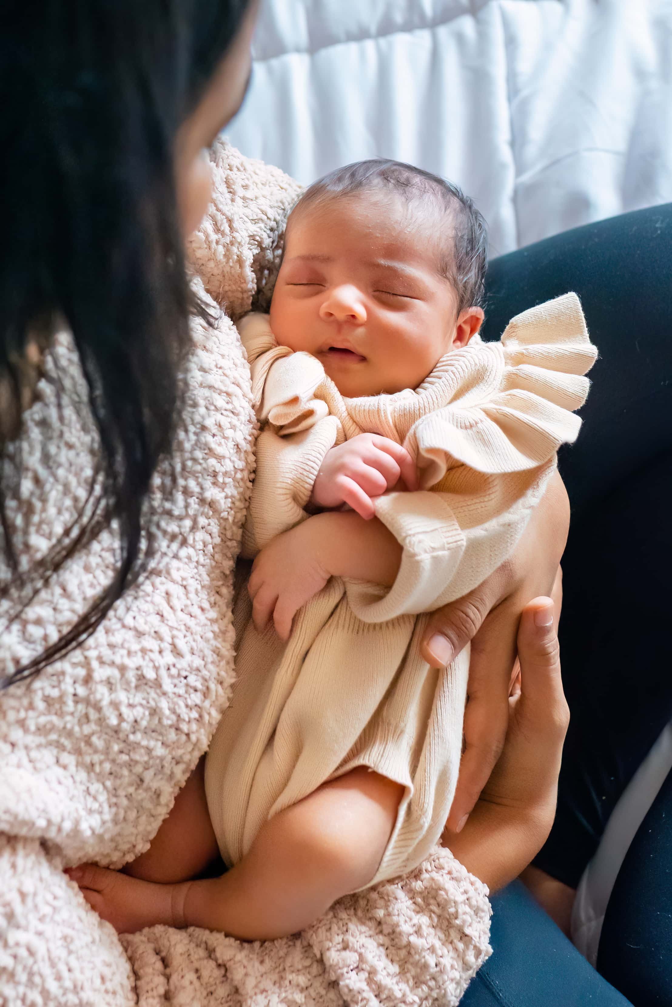 Newborn photograph of baby in her mom's arms