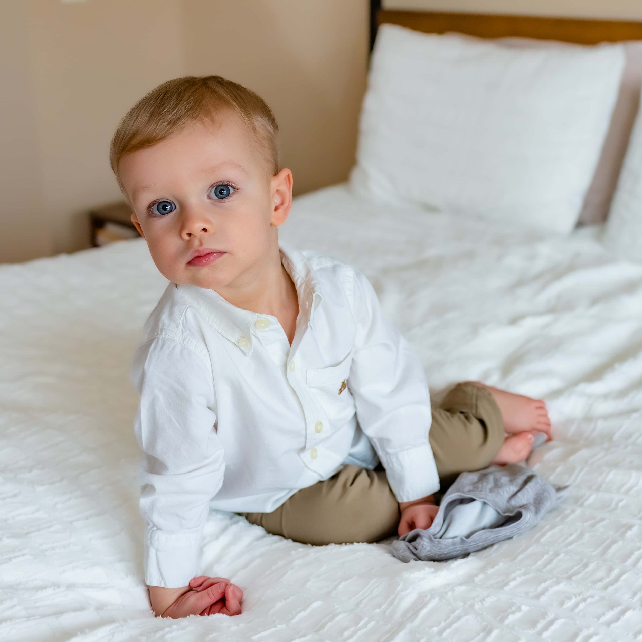 Maryland Lifestyle Newborn Photographer - toddler boy sitting on bed at newborn session 