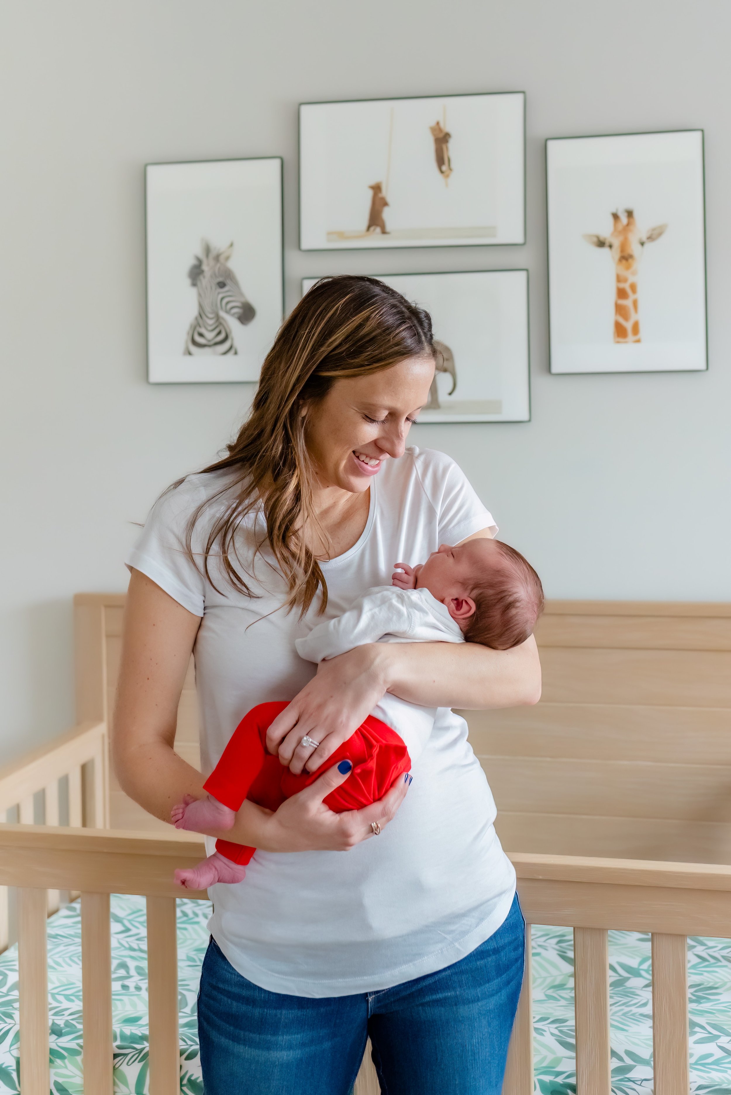 Maryland Lifestyle Newborn Photographer - mom cradling baby in nursery 