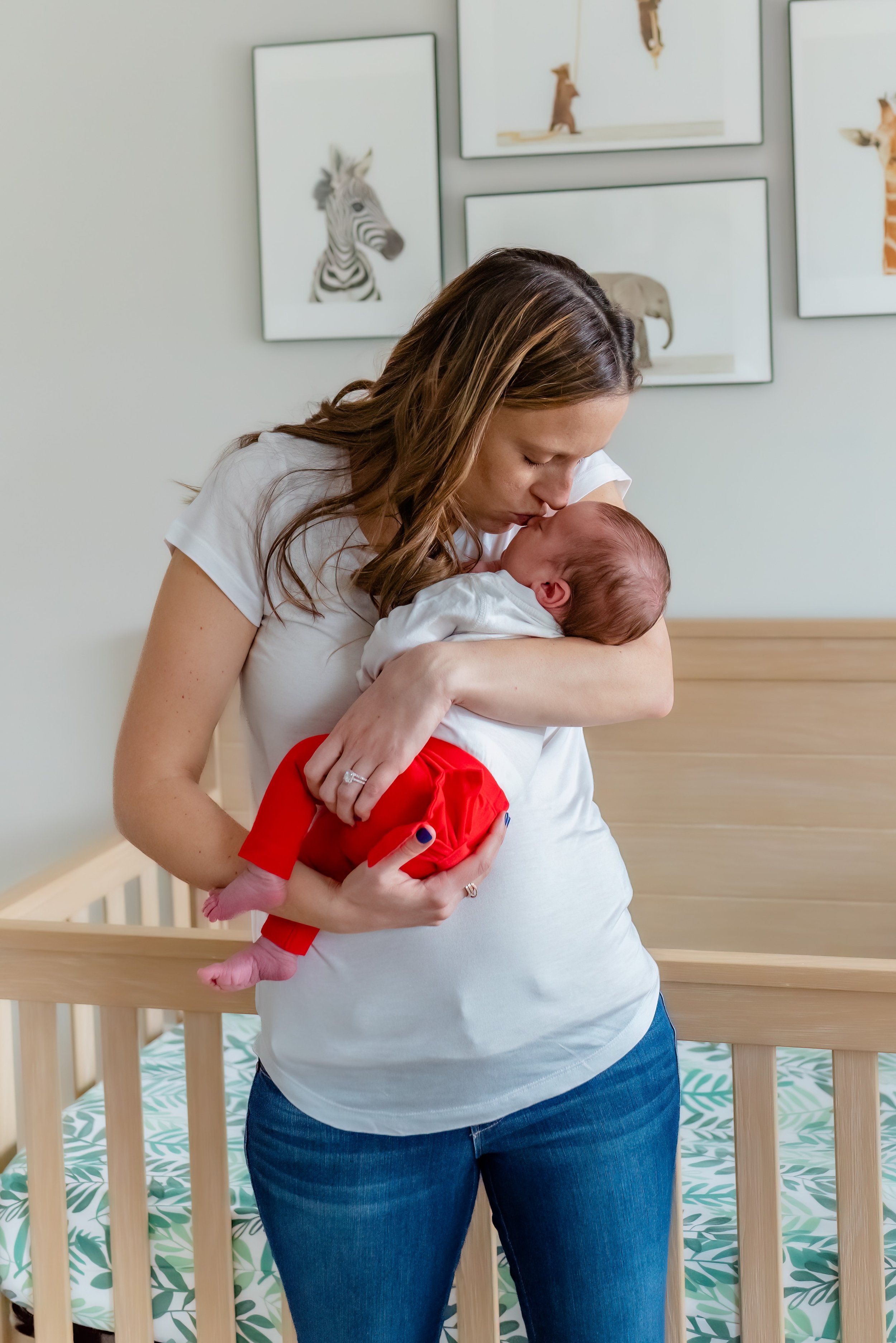 Maryland Lifestyle Newborn Photographer - mom cradling  and kissing baby 