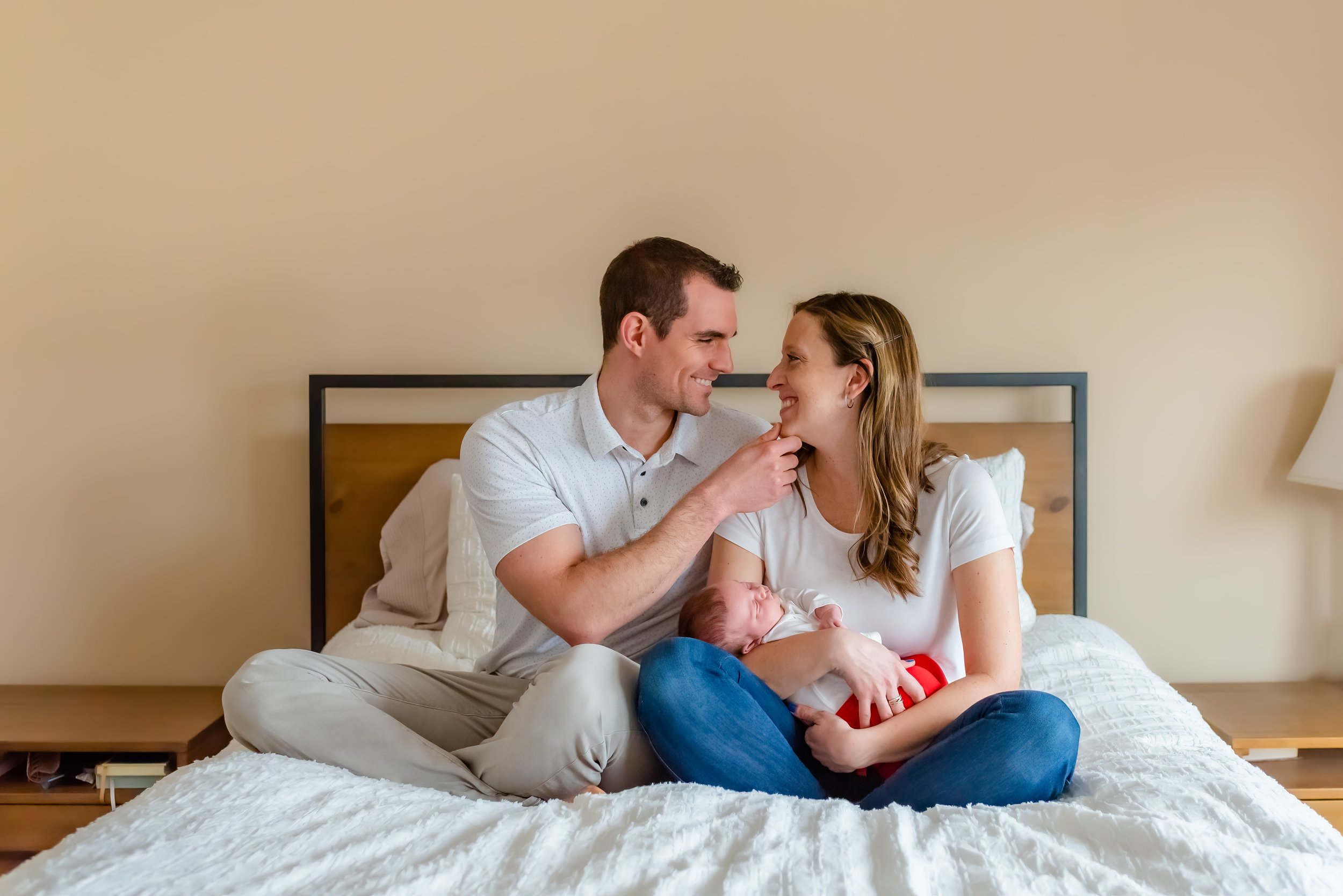 Maryland Lifestyle Newborn Photographer - Mom and dad smiling at each other during newborn session  