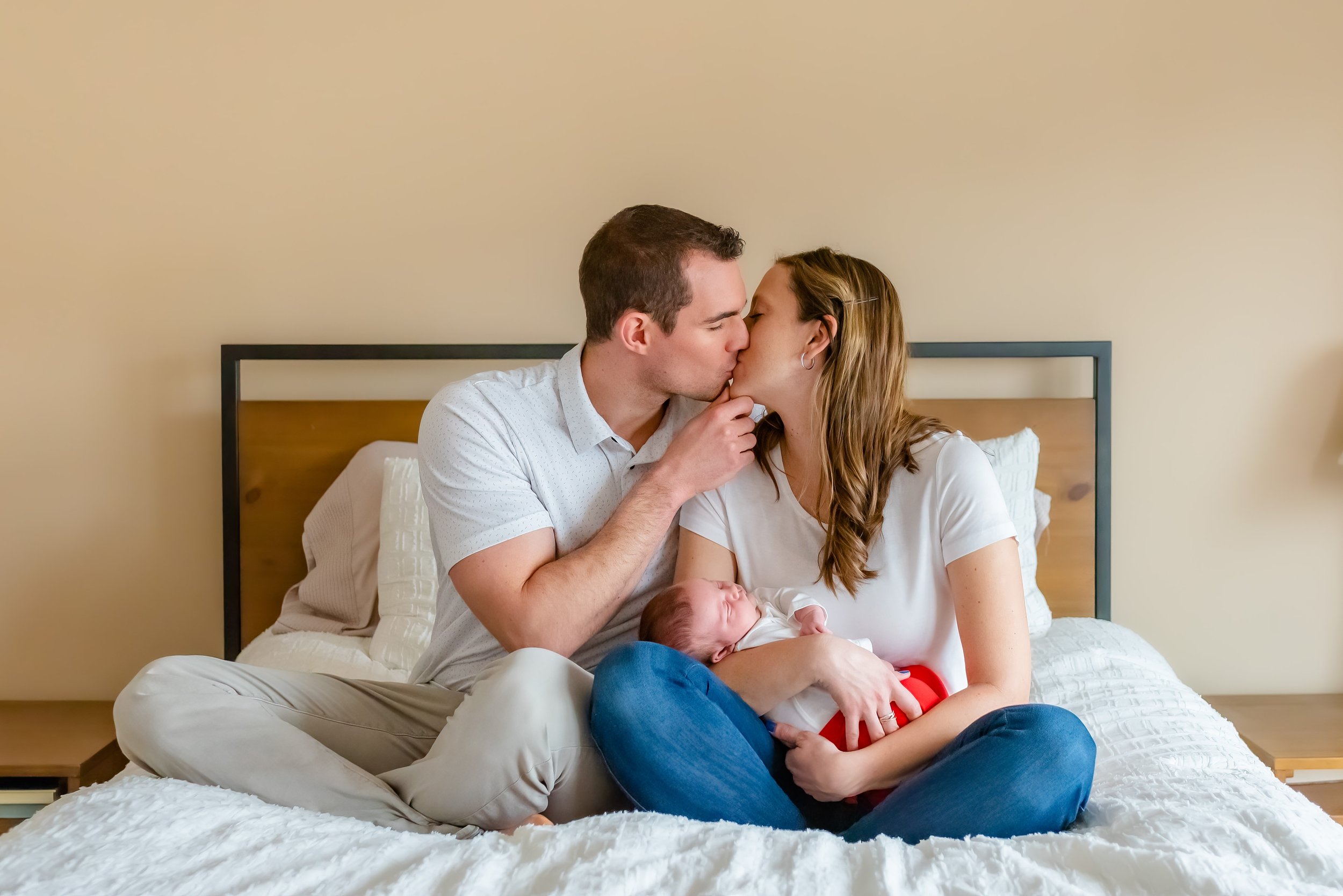 Maryland Lifestyle Newborn Photographer - Mom and dad kissing during newborn session  