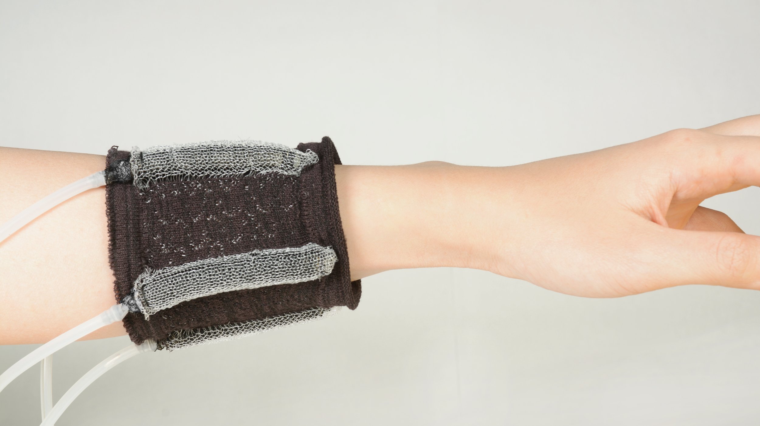  KnitSkin demonstrates potential as a wearable interface carrying a microphone. The interface locomotes down the arm to help a user pick up calls or send voice messages.&nbsp; (Photo: Hybrid Body Lab) 
