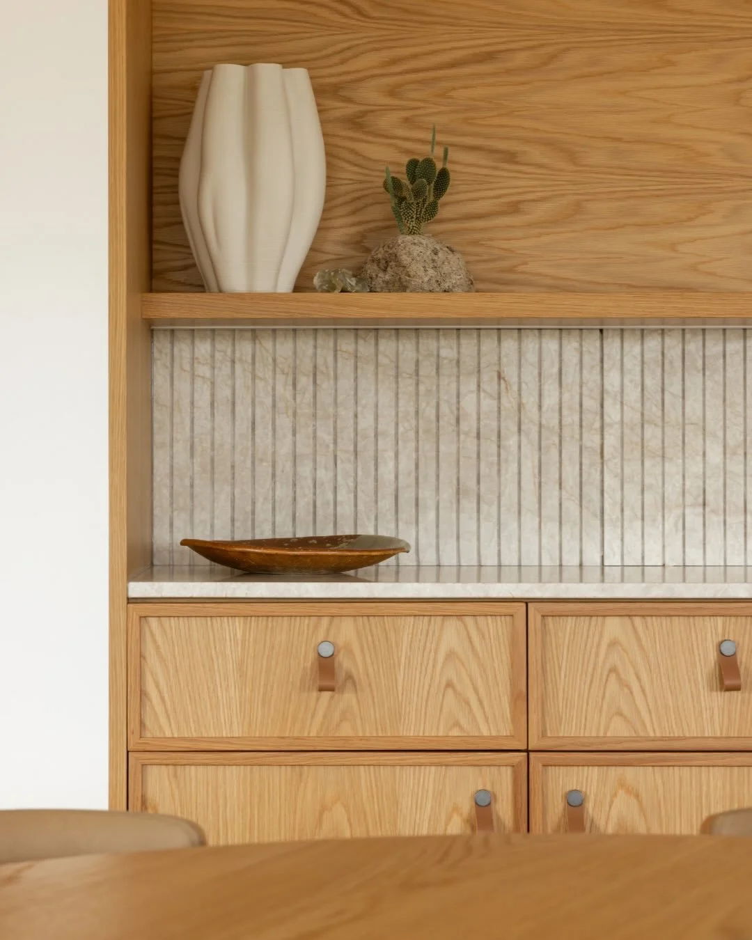Loving the island which sits lightly on legs to maintain an airy feel, featuring a single slab of @cosentino_nz leathered Sensa Taj Mahal across both island and sideboard. 
The offcut is repurposed as the splashback, with custom fluting concealing th