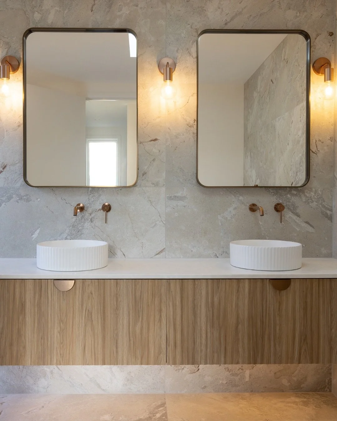 Project Profile: Vine Ave Residence 
Soft natural tones, warm timber, and copper finishes create a calm, understated bathroom at our Vine Ave Residence. 
The @plumbline_bathware Frame XL Mirrors bring a beautifully simple finishing detail to the doub
