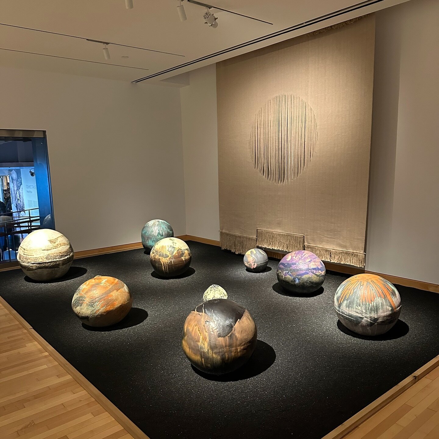My favorite moment from the newly opened Toshiko Takaezu exhibition at the Noguchi. A planetary system of Toshiko's iconic closed forms orbiting the soft sun of Lenore Tawney's weaving 💕