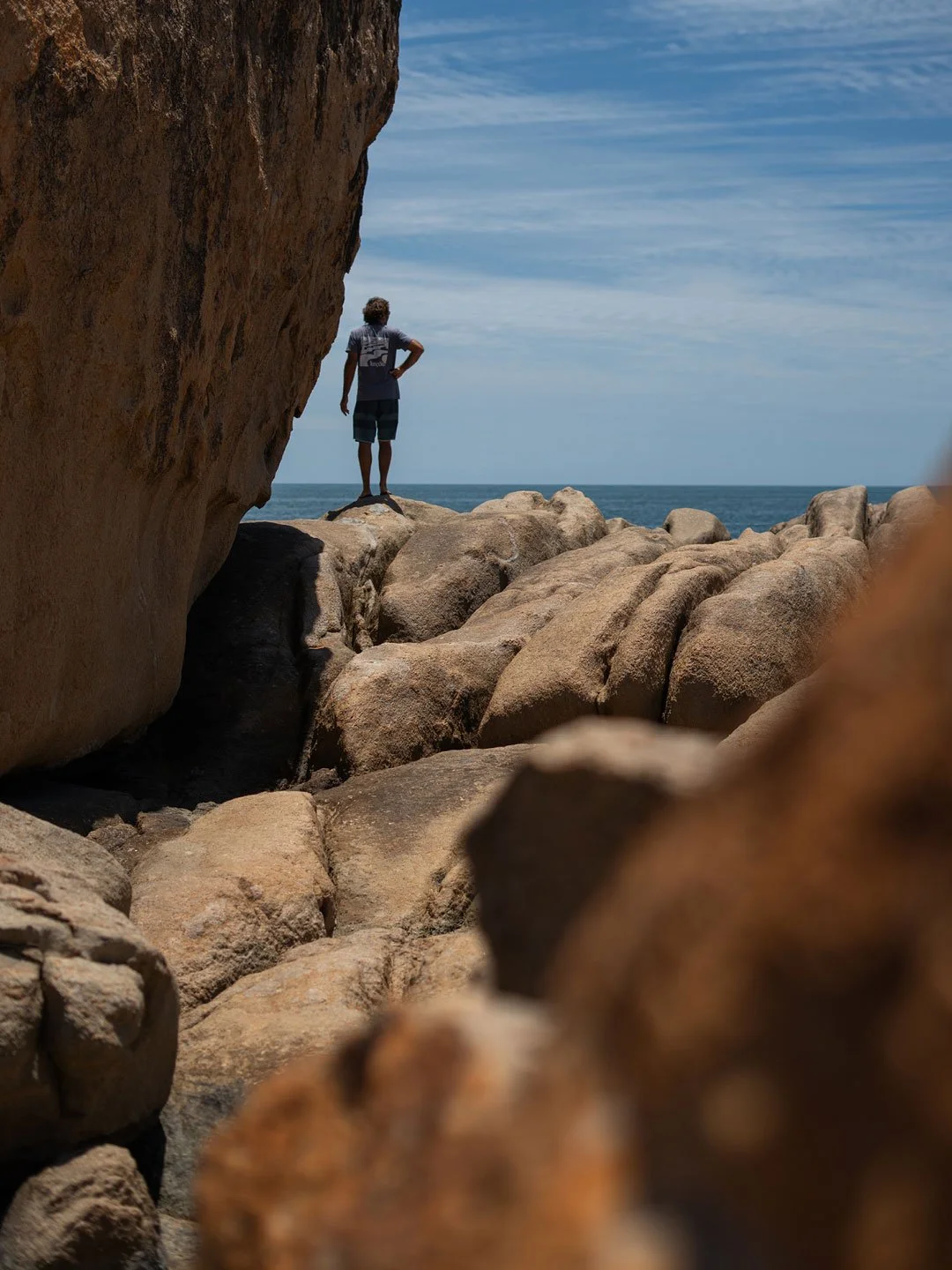 Person standing beside giant coastal rock formation in Australia