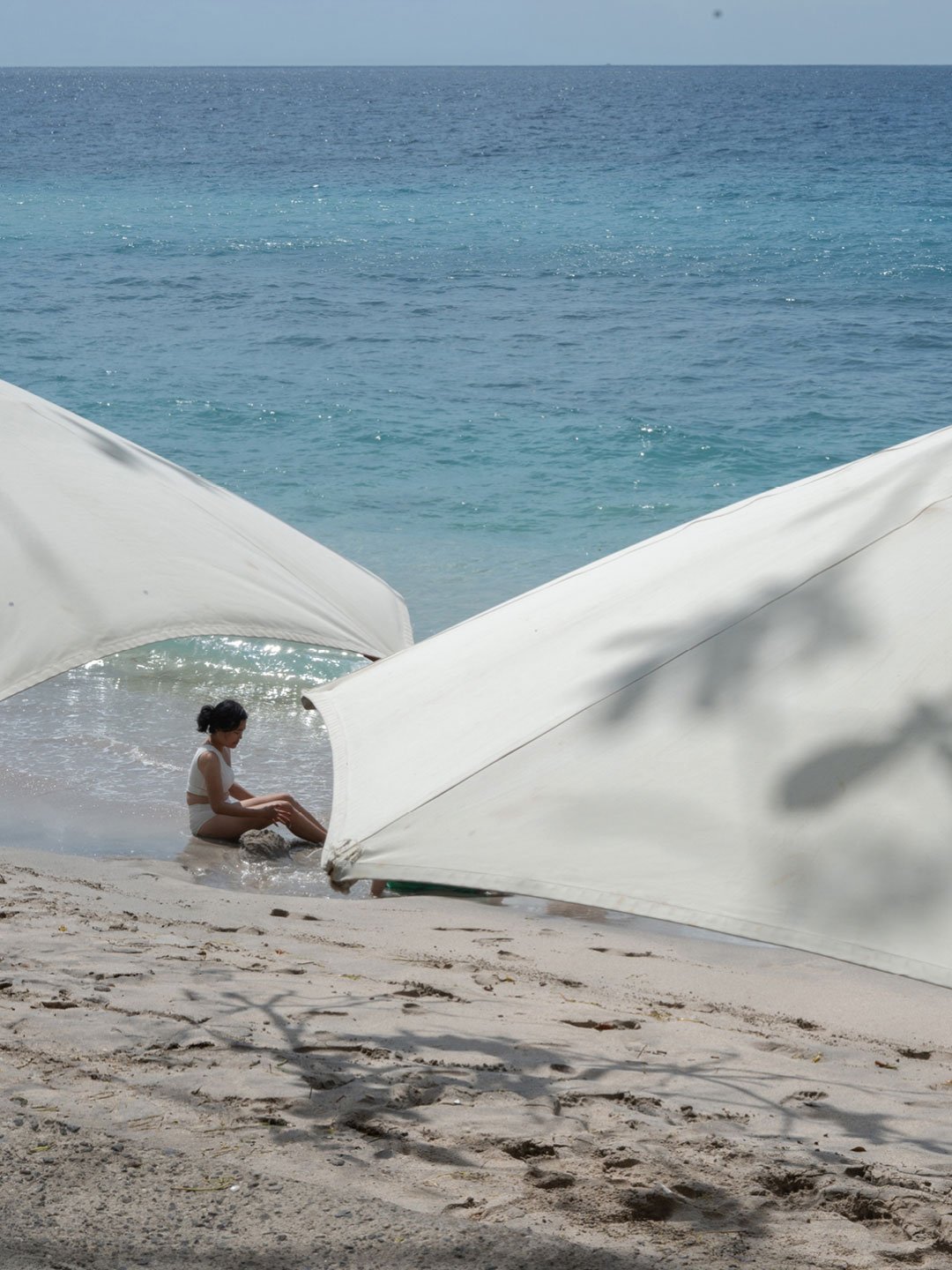 Relaxed beach scene with white umbrellas and turquoise ocean