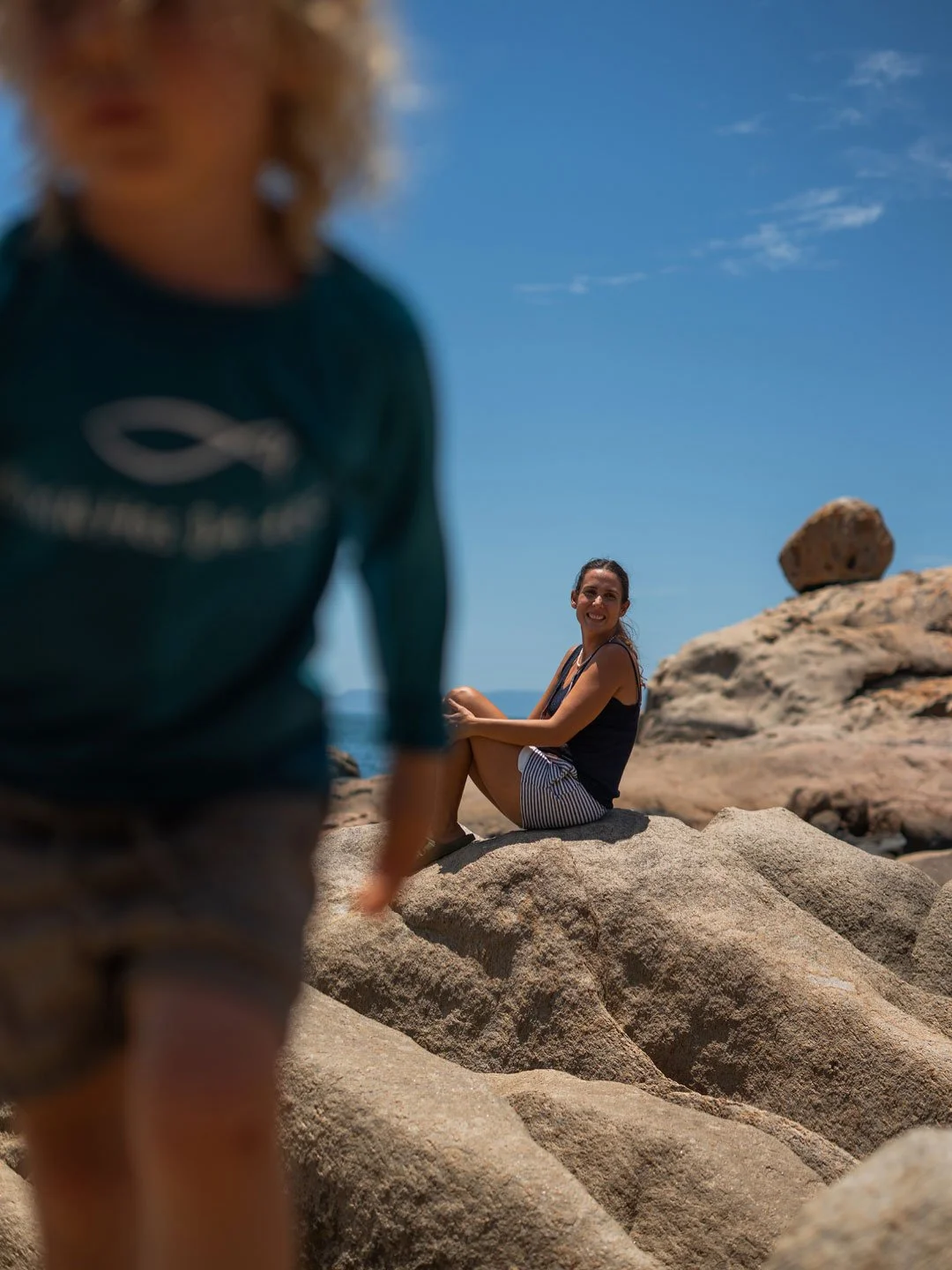Family exploring rocky coastline at Airlie Beach, Australia