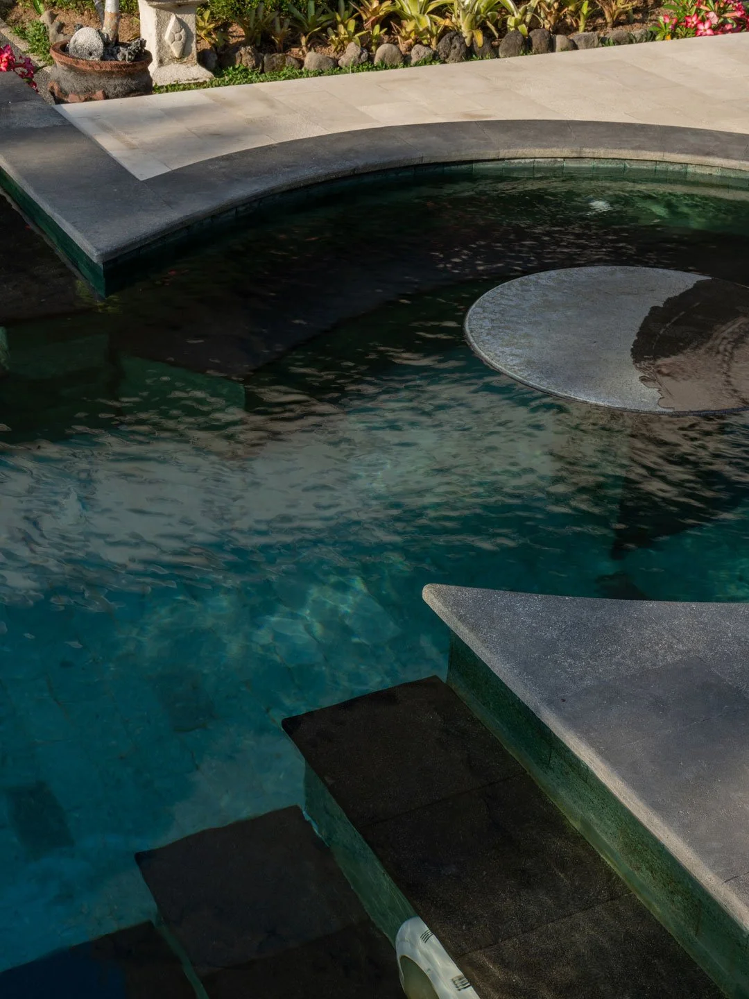 Curved swimming pool surrounded by tropical greenery in Bali