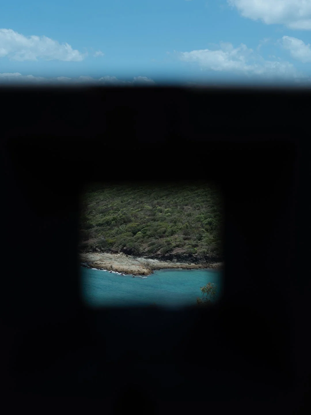 Framed coastal island view through dark interior window