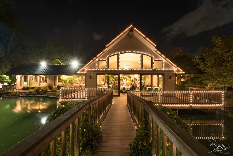 Night view of a house with string lights outlining its roof and a walkway leading to the entrance.