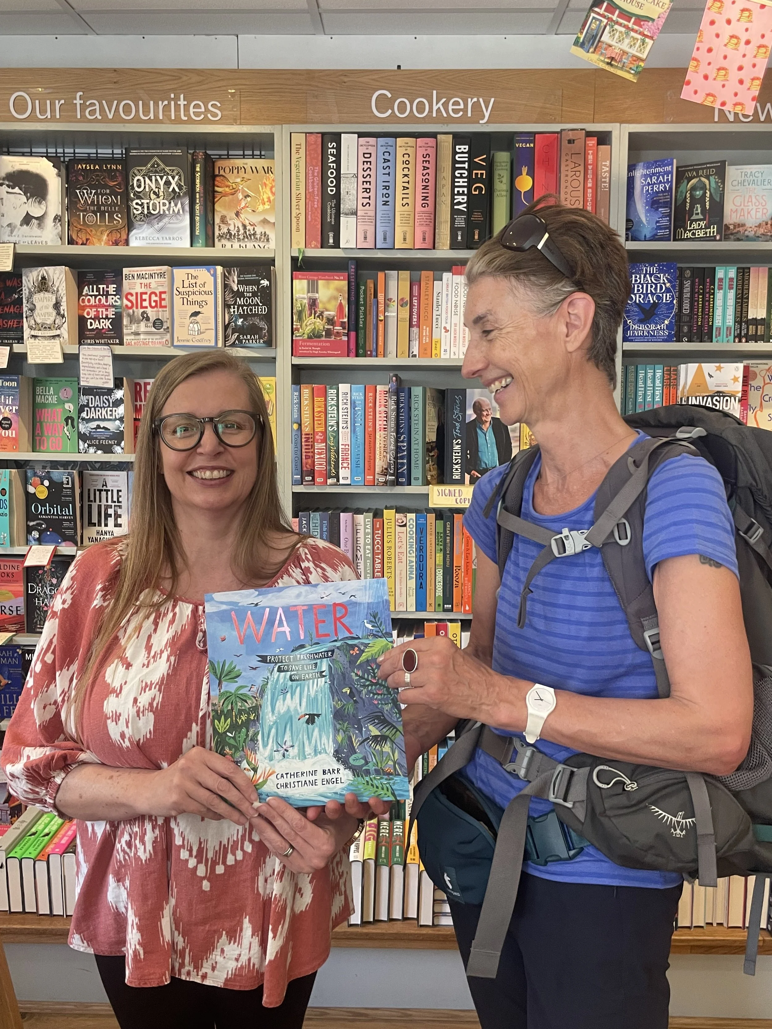 Catherine Barr with local book shop owner holding a copy of her book WATER.