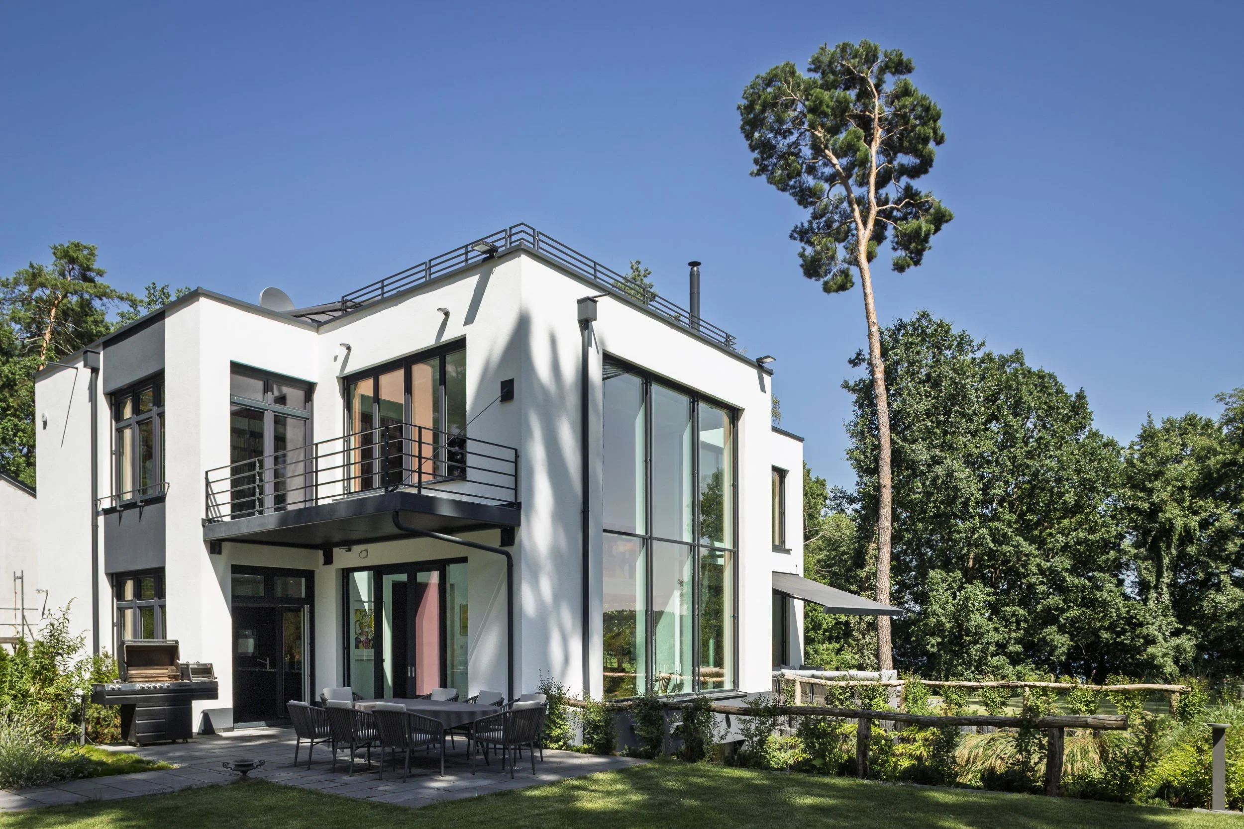 Moderne Villa mit großen Glasflächen und Garten.