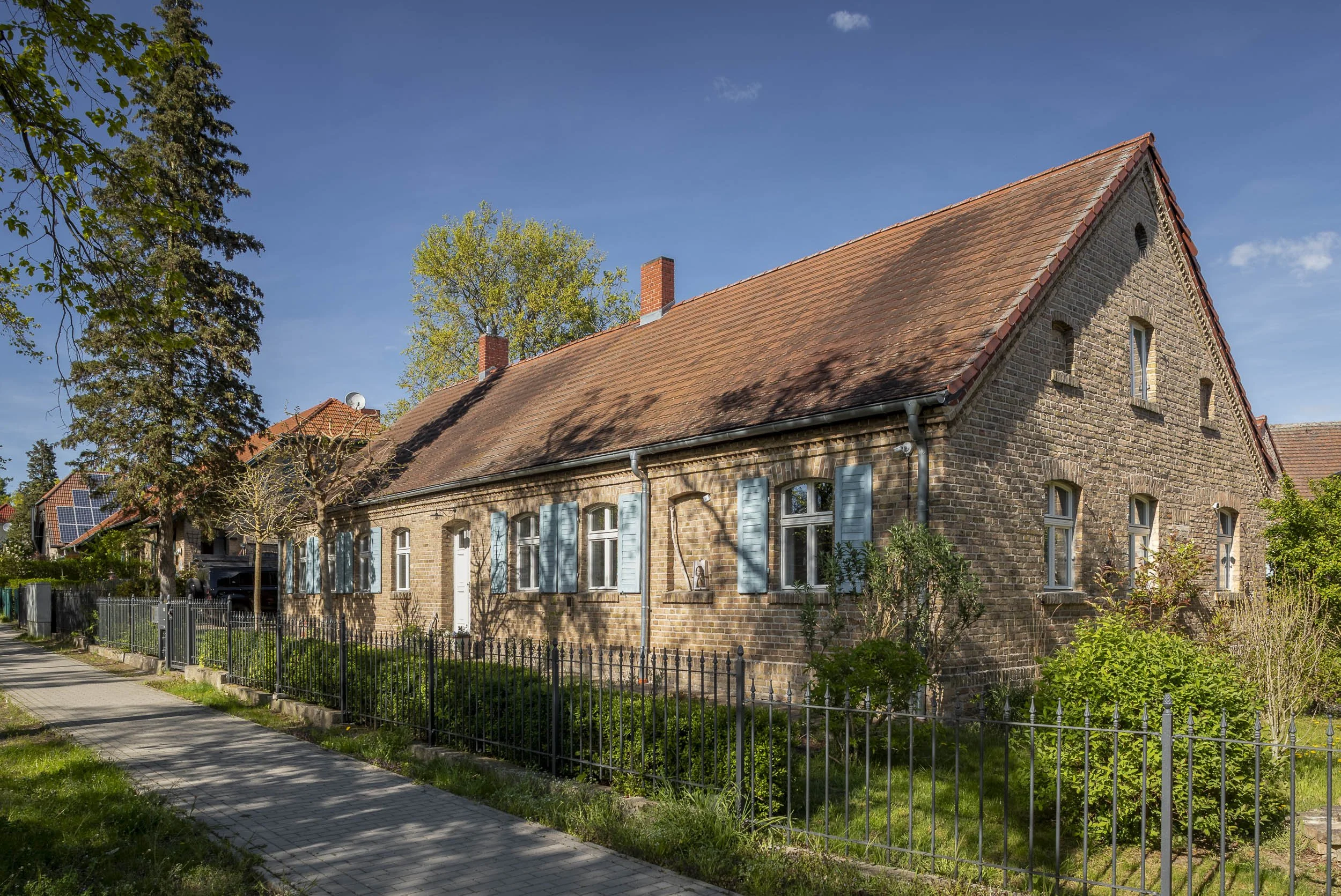 Historisches Backsteinhaus mit Garten und traditioneller Architektur.