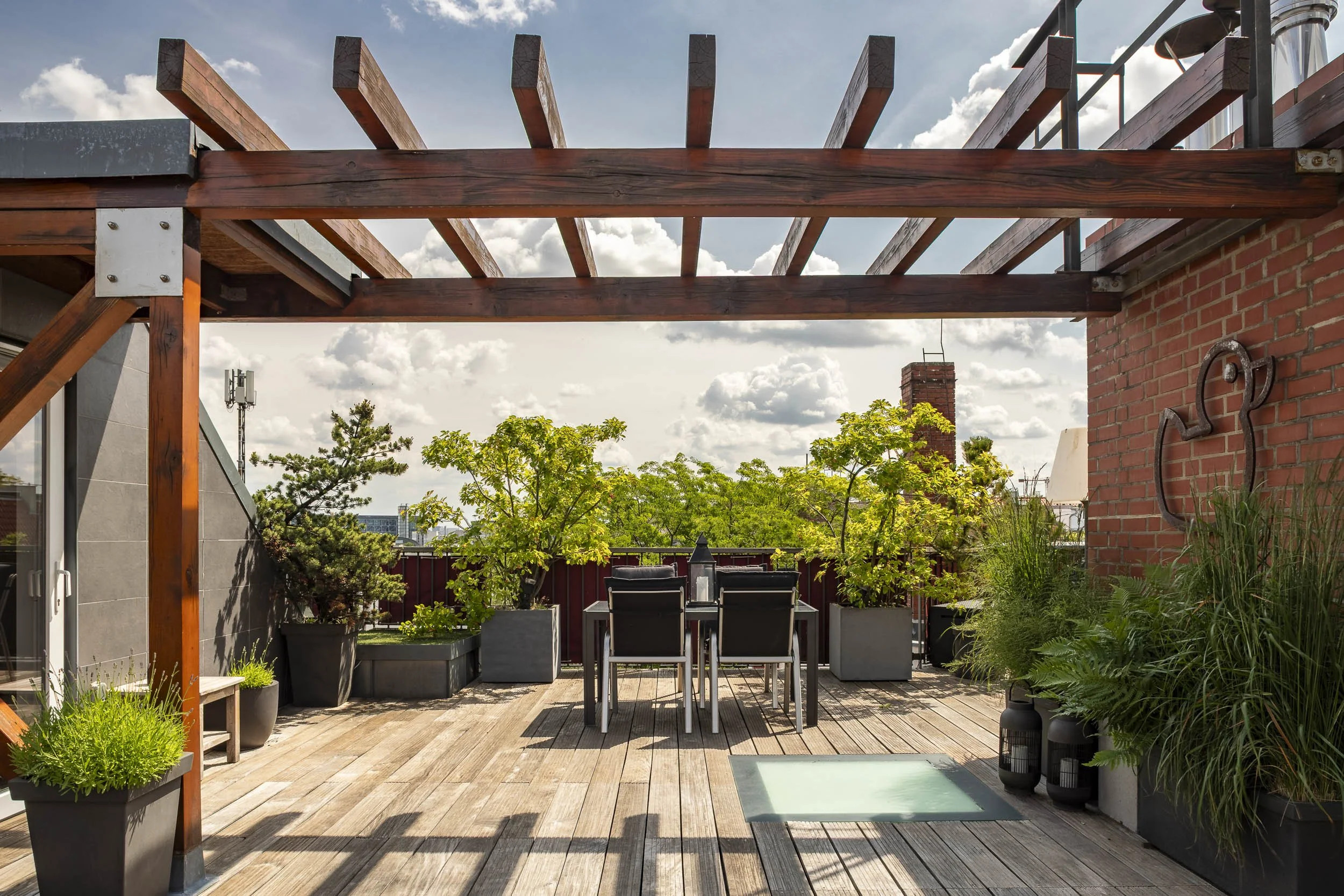Dachterrasse mit Pergola, Begrünung und großzügigem Essbereich.