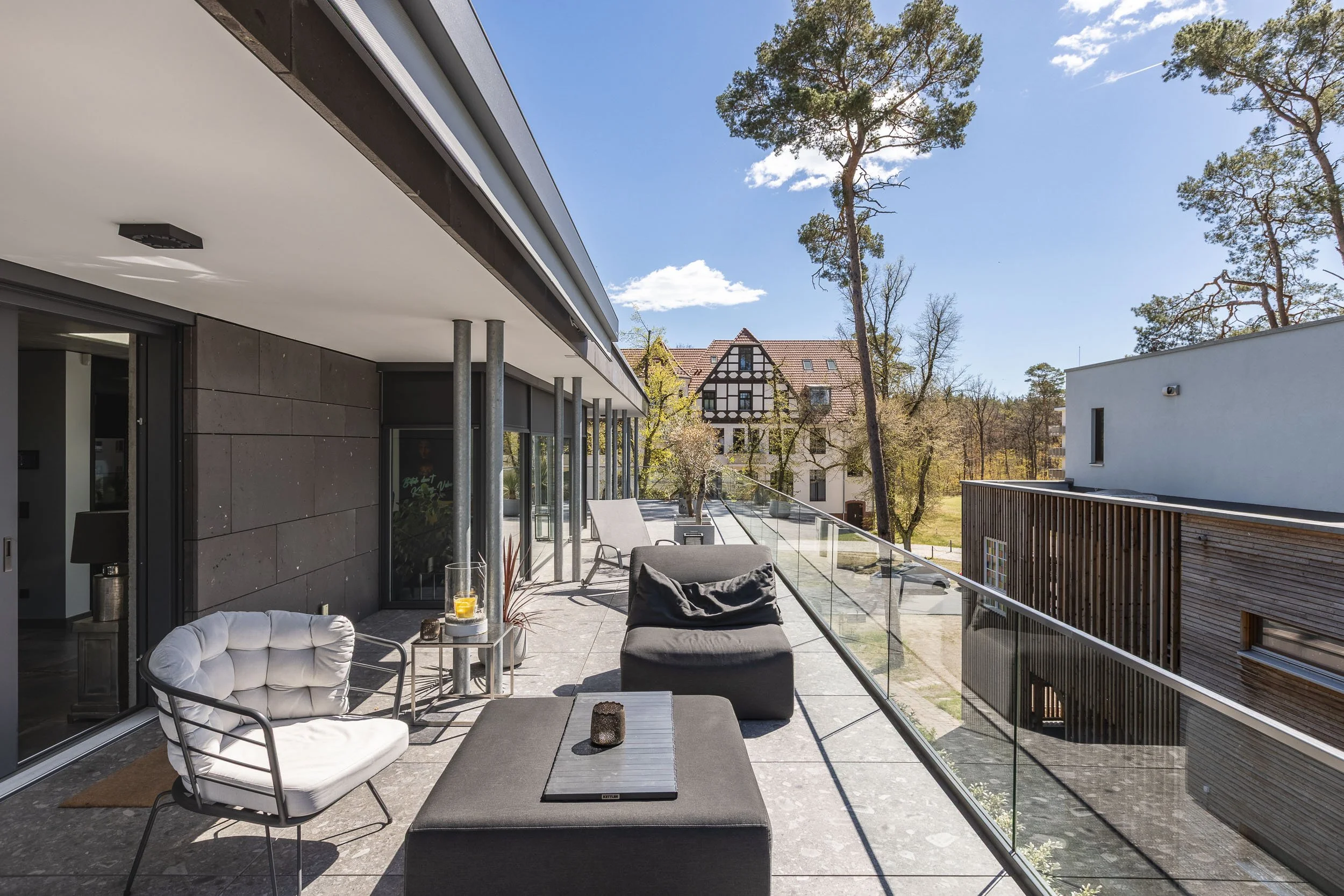 Terrasse mit Glasbrüstung und Blick ins Grüne.