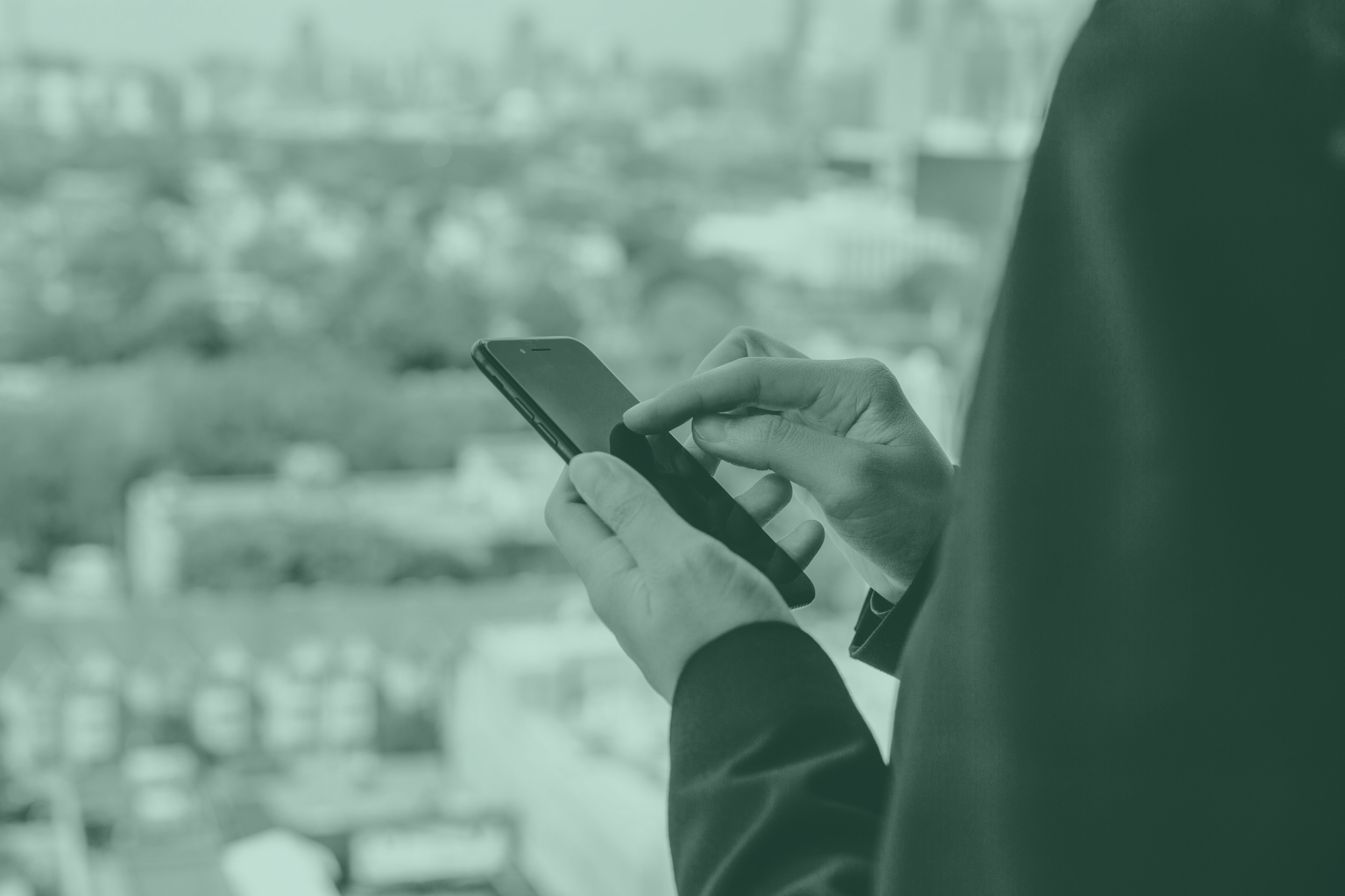 using-smartphone-with-city-in-the-background-greenoverlay.png