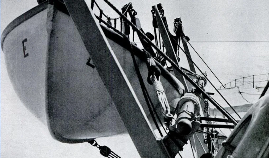 A close-up of the lifeboat and strong-back (lower right pole).
