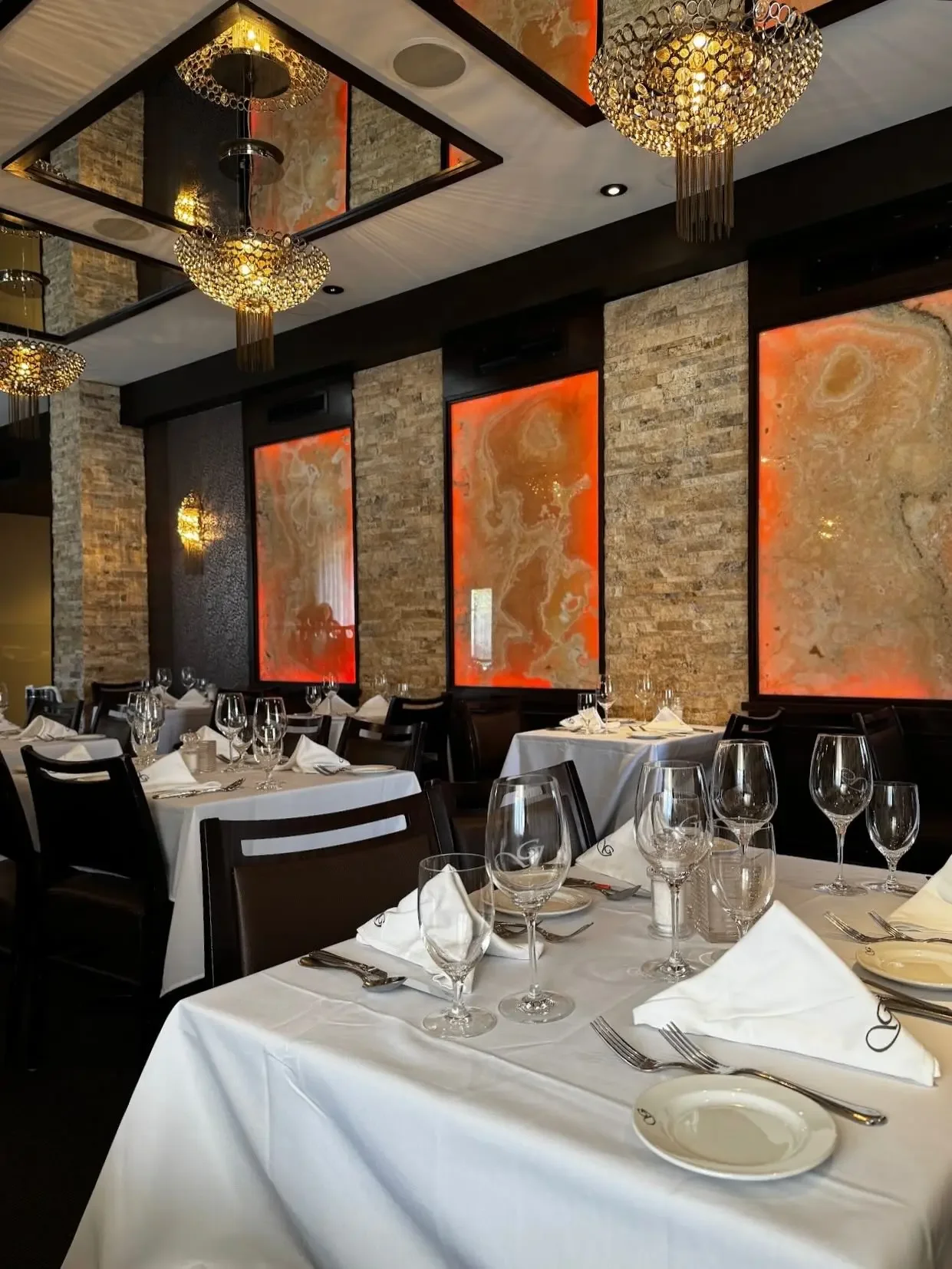 Elegant dining room at Giovanni's Restaurant set with white tablecloths and wine glasses, perfect for a traditional Easter dinner in Ottawa.