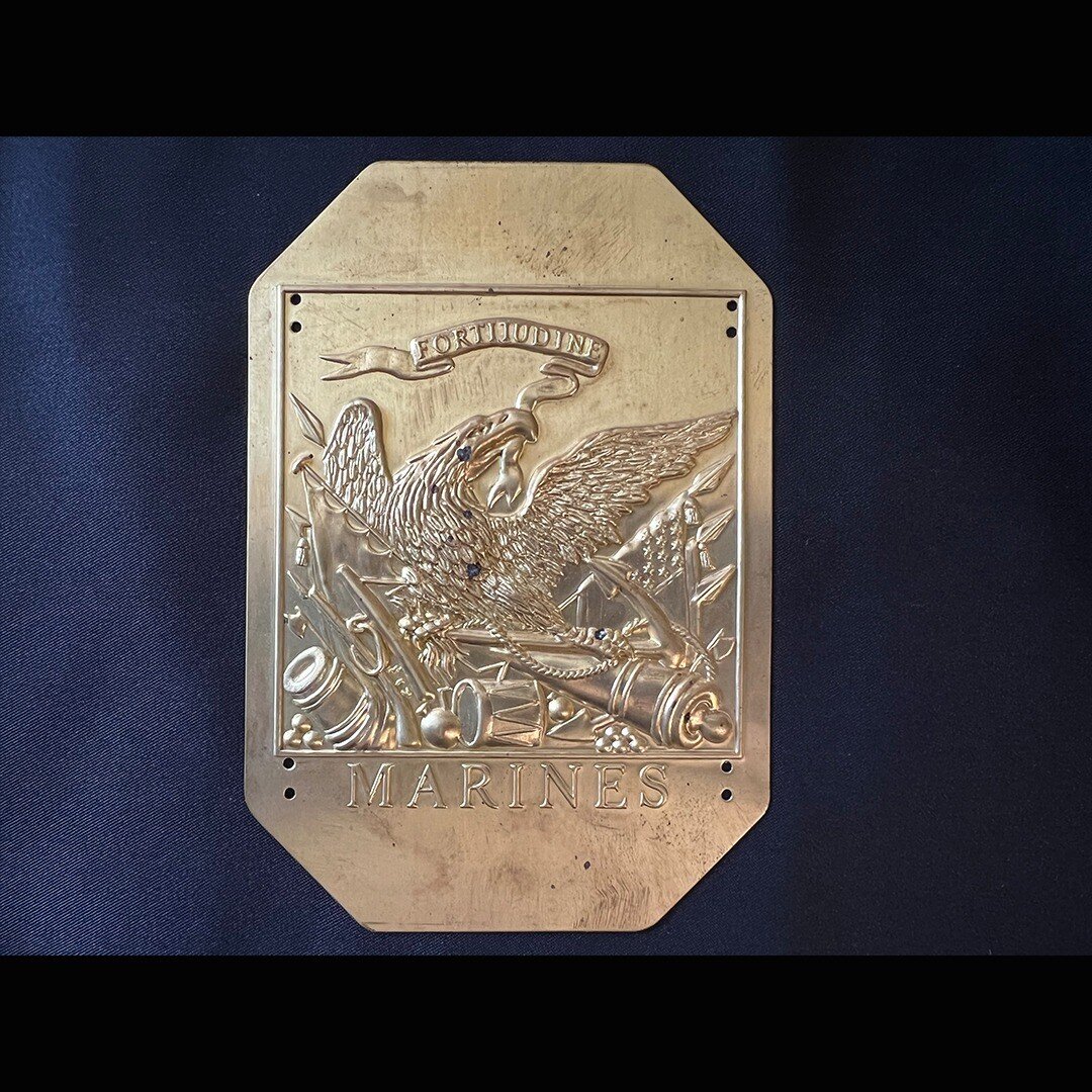 Last year, I picked up a replica of an enlisted Marine's hat plate circa 1812. The scroll in the eagle's beak reads &quot;Fortitudine,&quot; the original motto of the Corps. The details in the replica are impressive. 

During the War of 1812, Marines