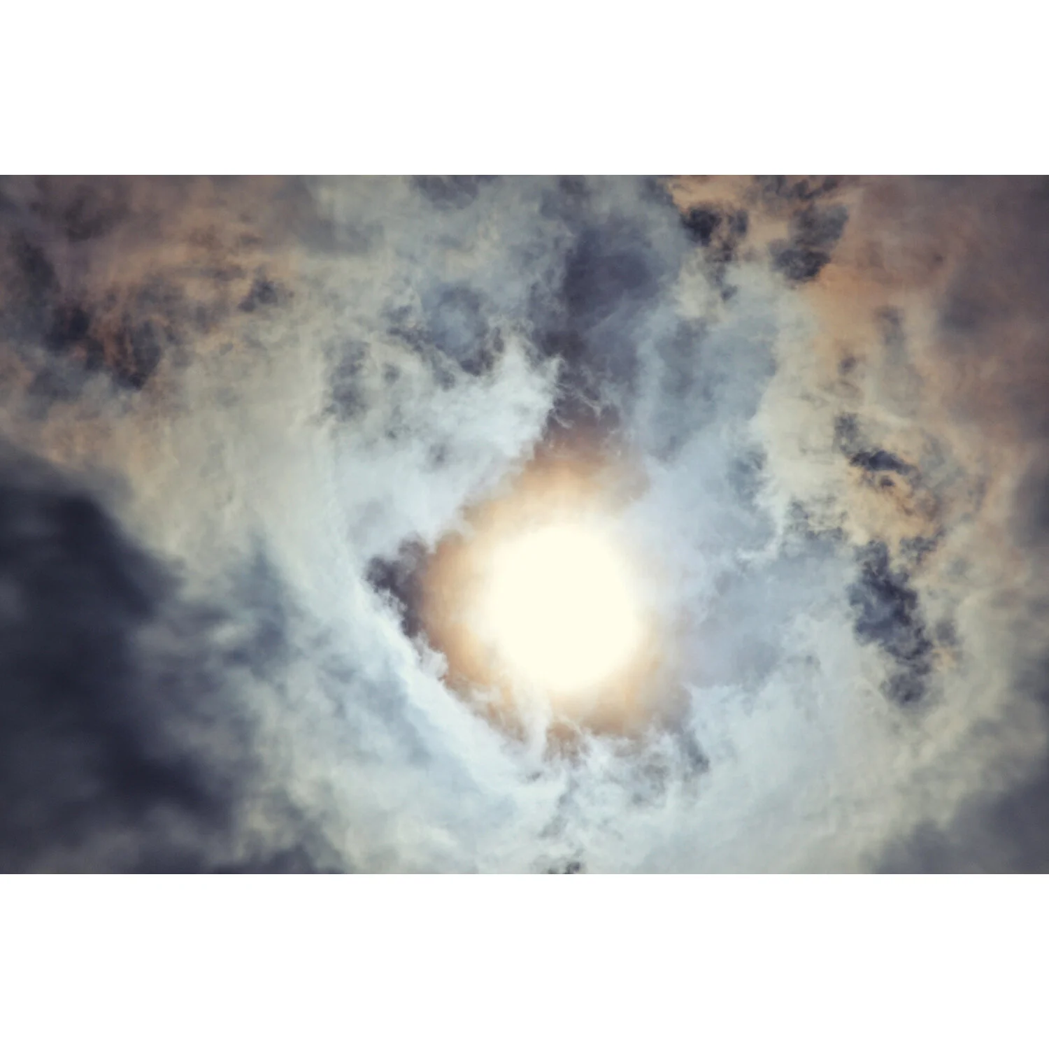 "Solar Eclipse with Swirling Clouds" Photo by Kay Phelps