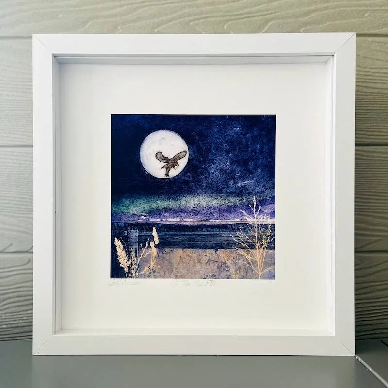 An open edition landscape art print in a white box frame featuring an owl against full moon on the hunt - Indigo and manganese blue sky - abstract foreground with mauves and blue greens highlights