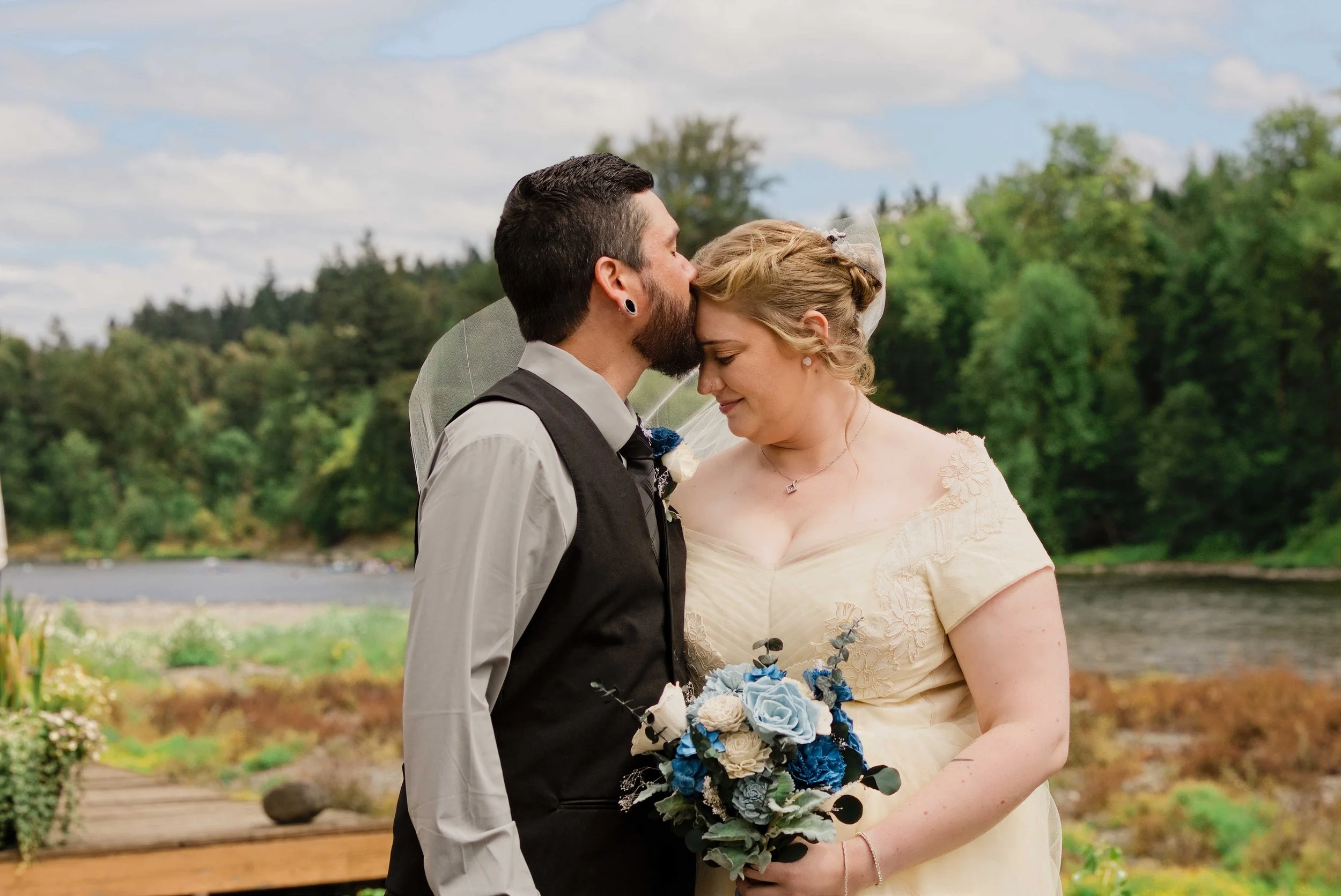 Jodiee and Ethan kissing on the lawn above the Clackamas River