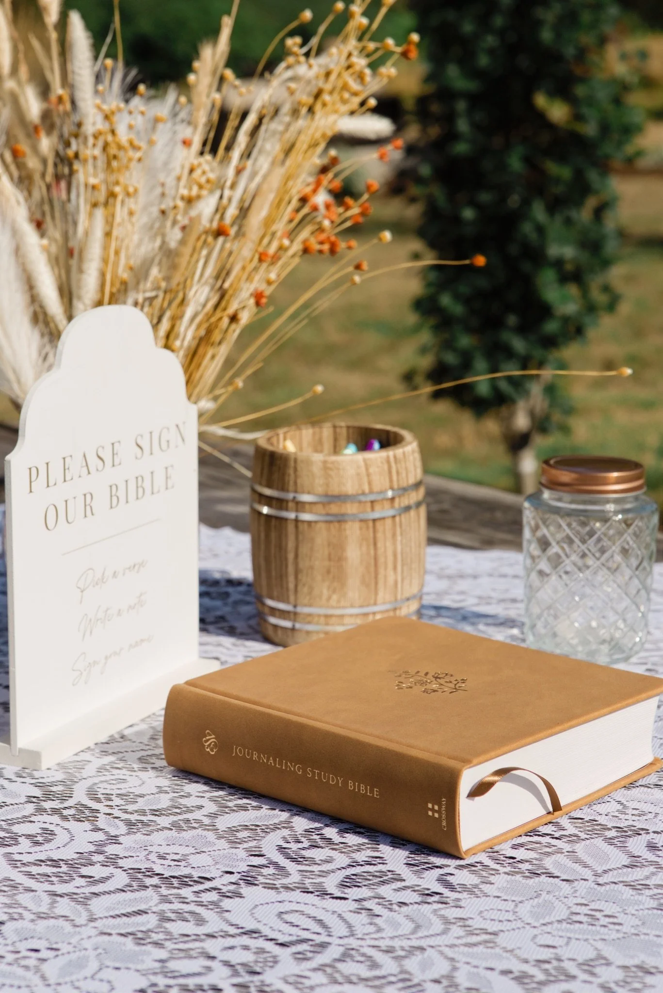 The wedding guest book and a wooden box with dried florals on the welcome table