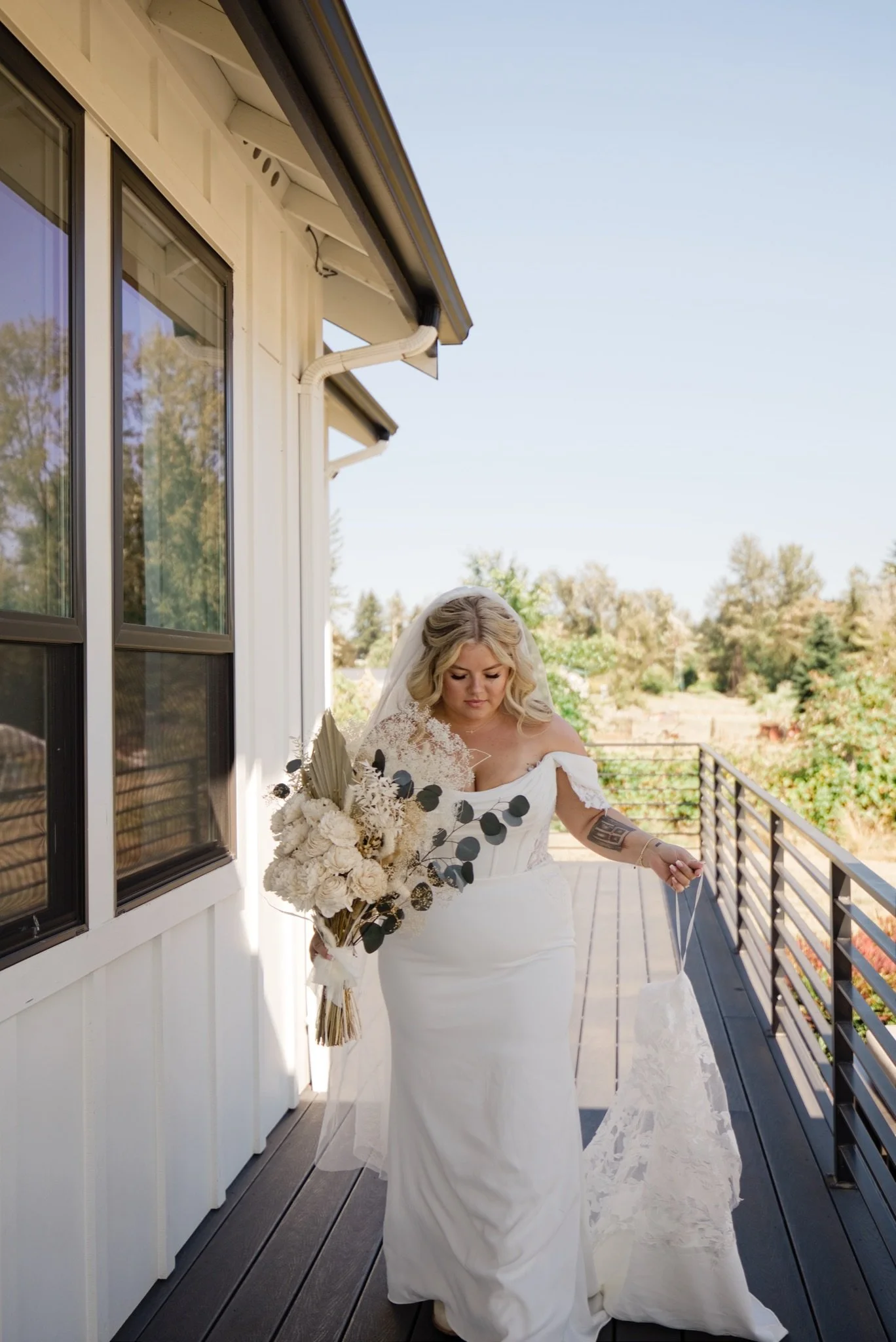 Sarah in her wedding dress walking out onto the deck with her bouquet