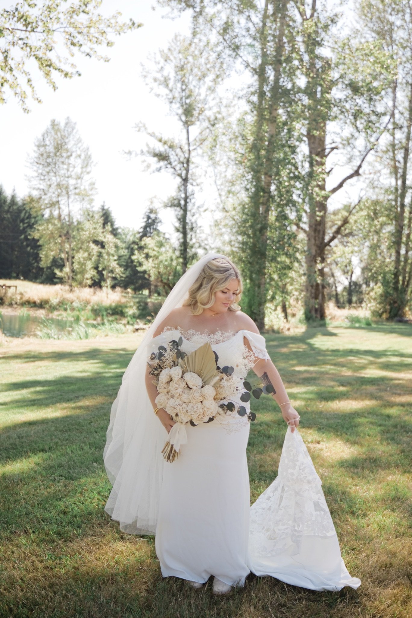 Sarah walking across the lawn with her bouquet and veil