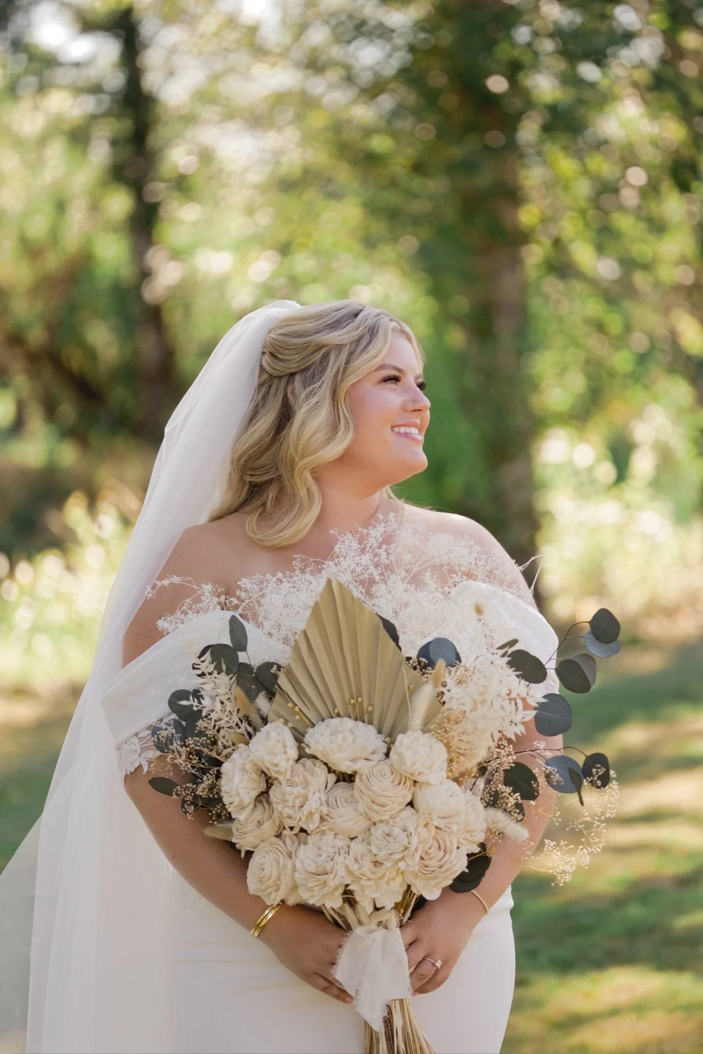 Sarah in her veil holding her cream and white bouquet