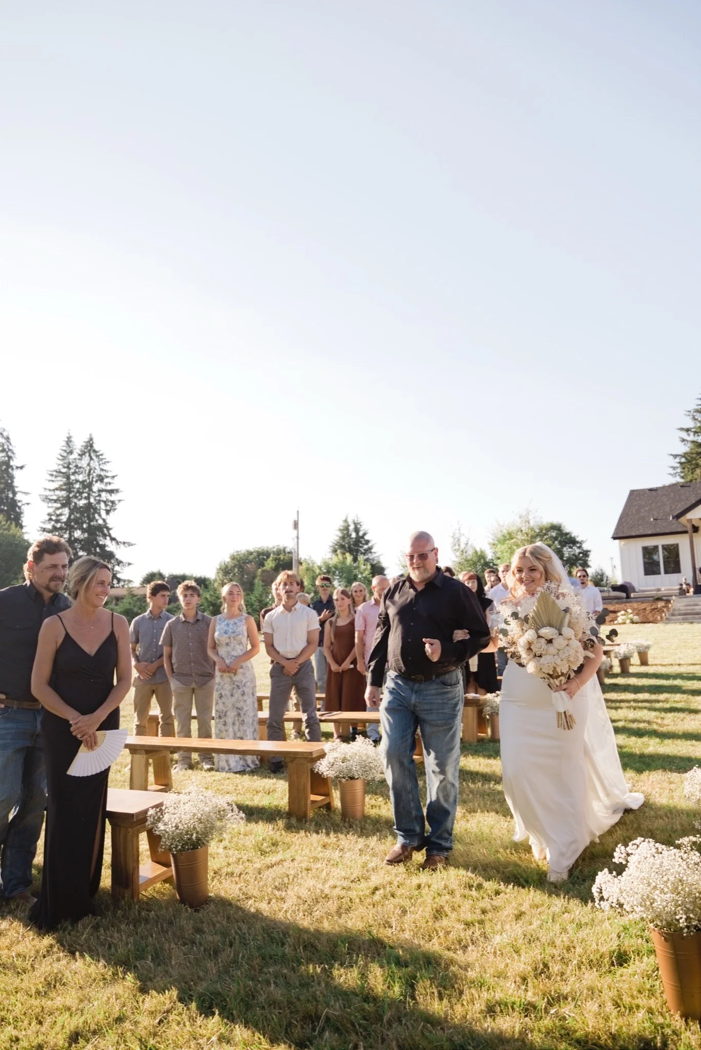 The wedding party lined up along the aisle in the meadow