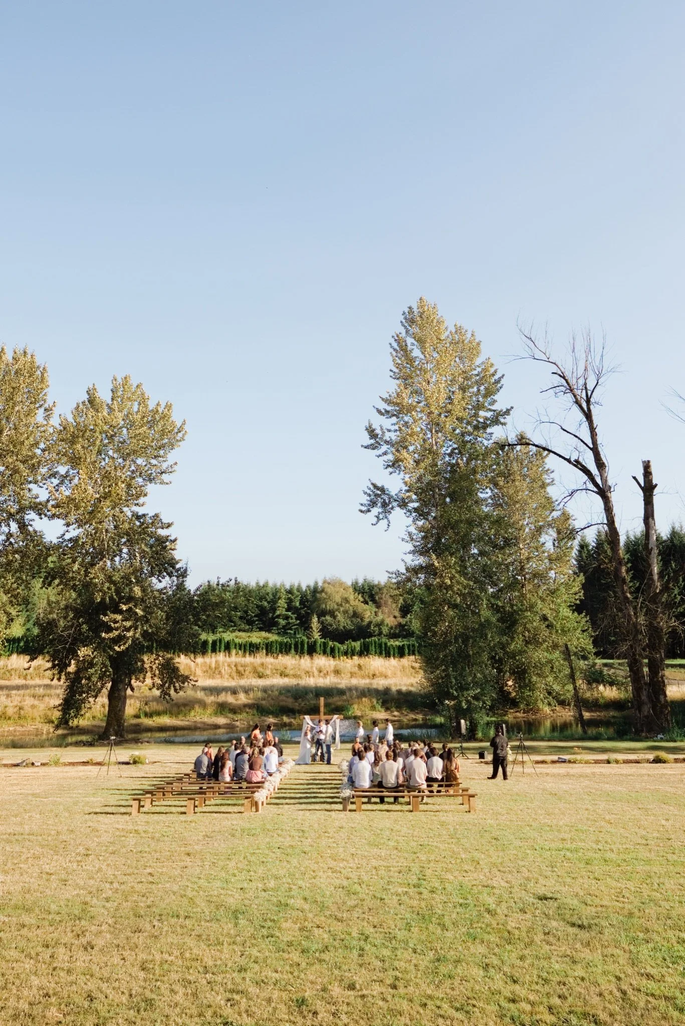 Guests gathered in the meadow for the ceremony under the cedars