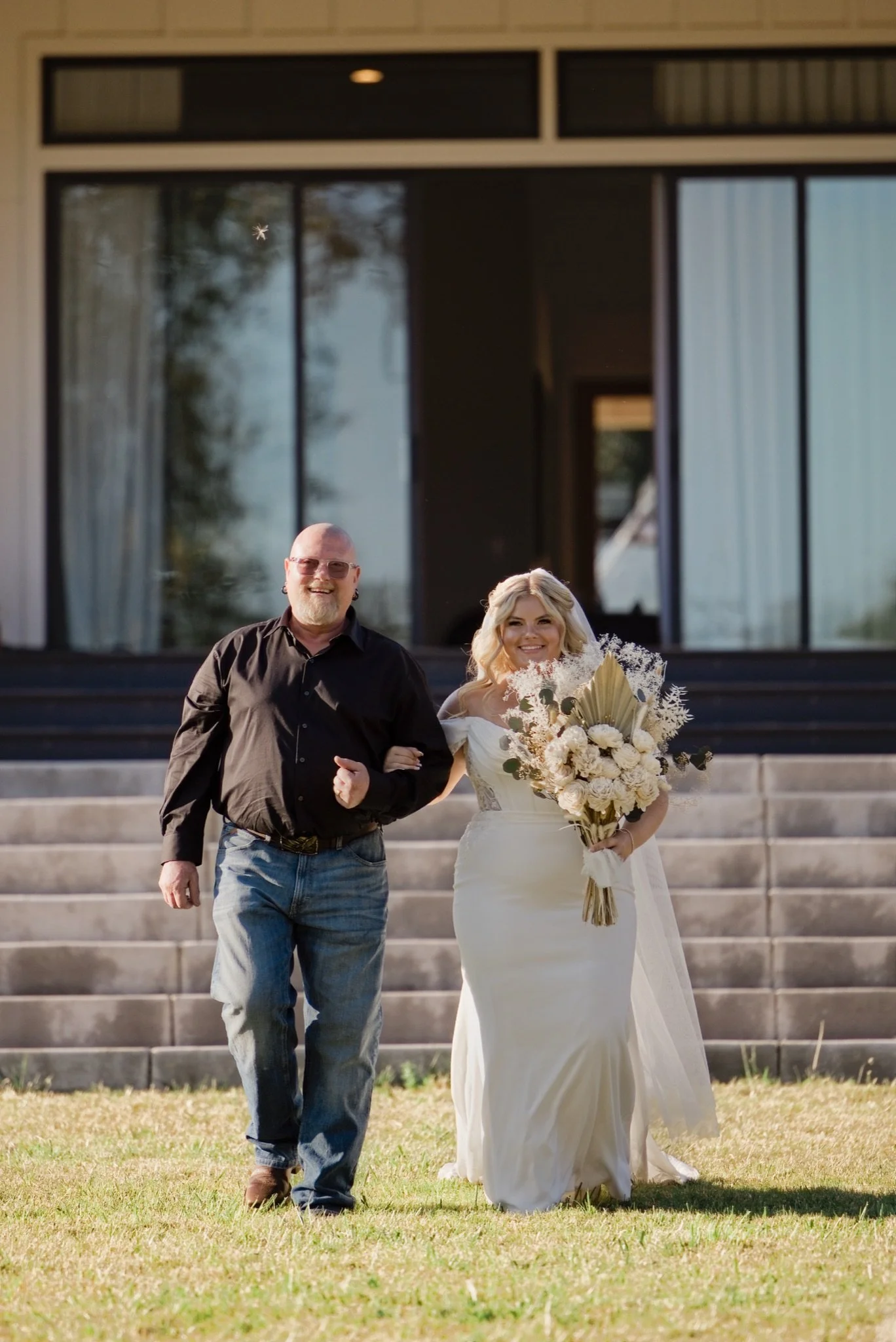 Sarah walking down the steps on her dad's arm