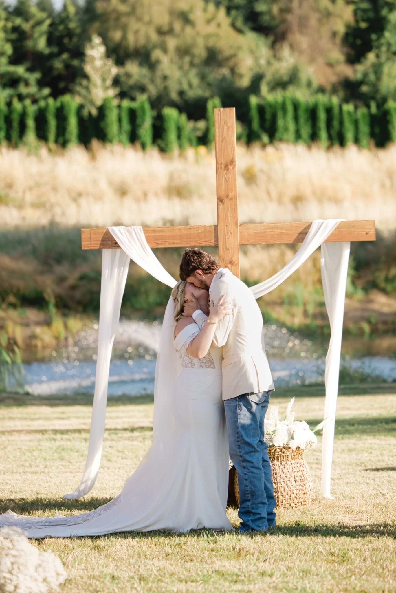 Sarah and Reed exchanging vows under the wooden cross arch