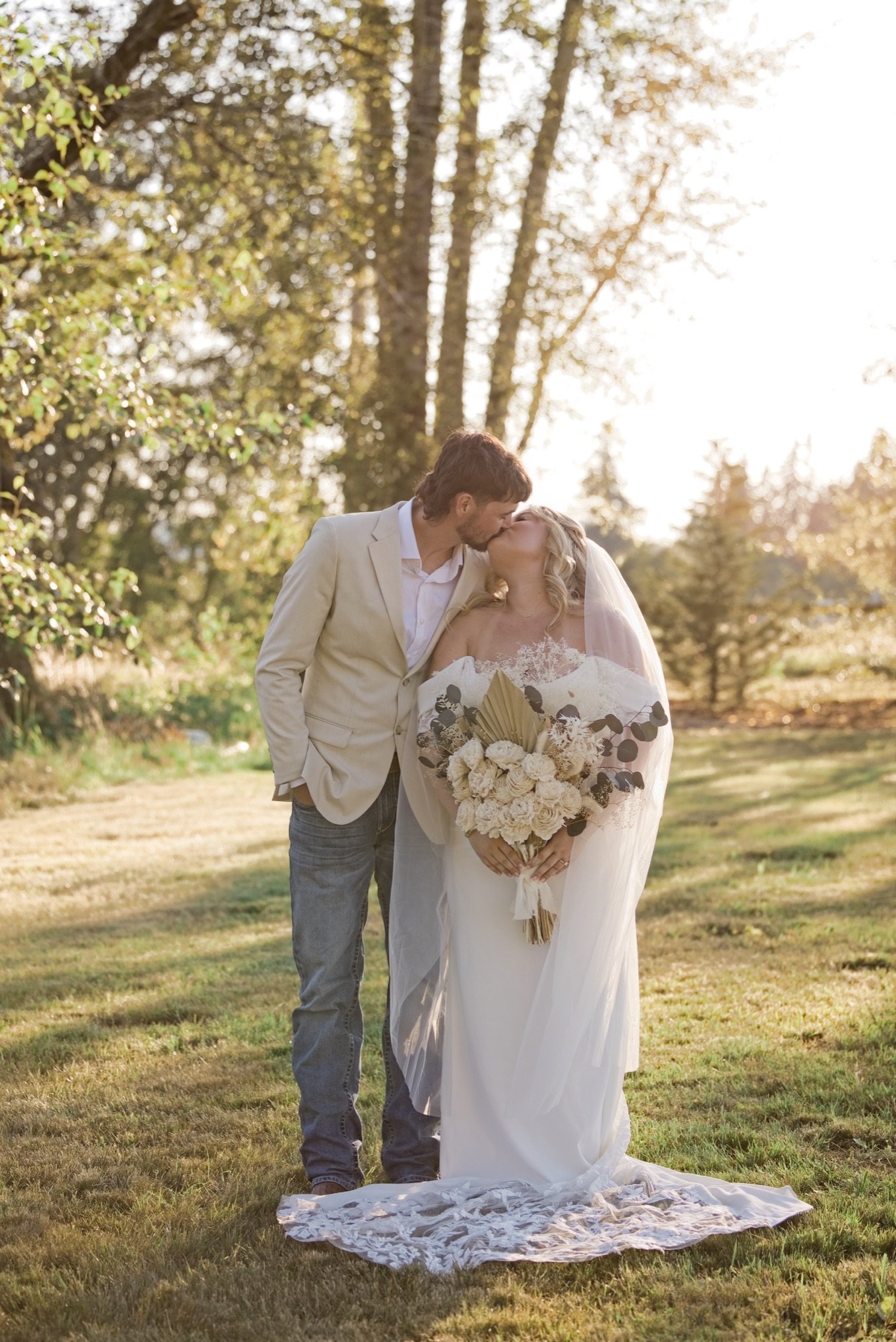 Reed kissing Sarah's forehead on the lawn at golden hour
